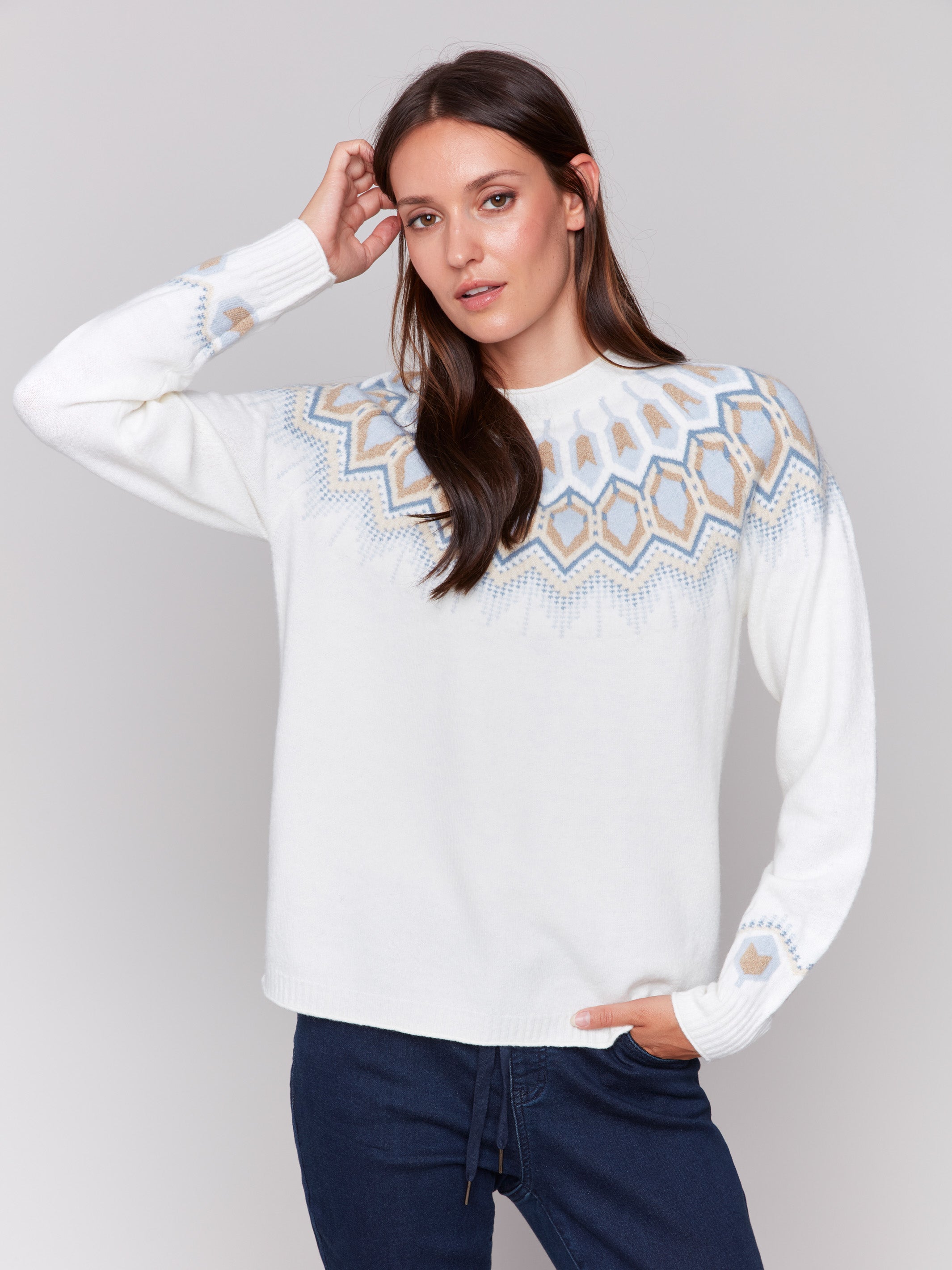 Cream white long-sleeve ski sweater with geometric jacquard patterns and raglan sleeves by Charlie B.