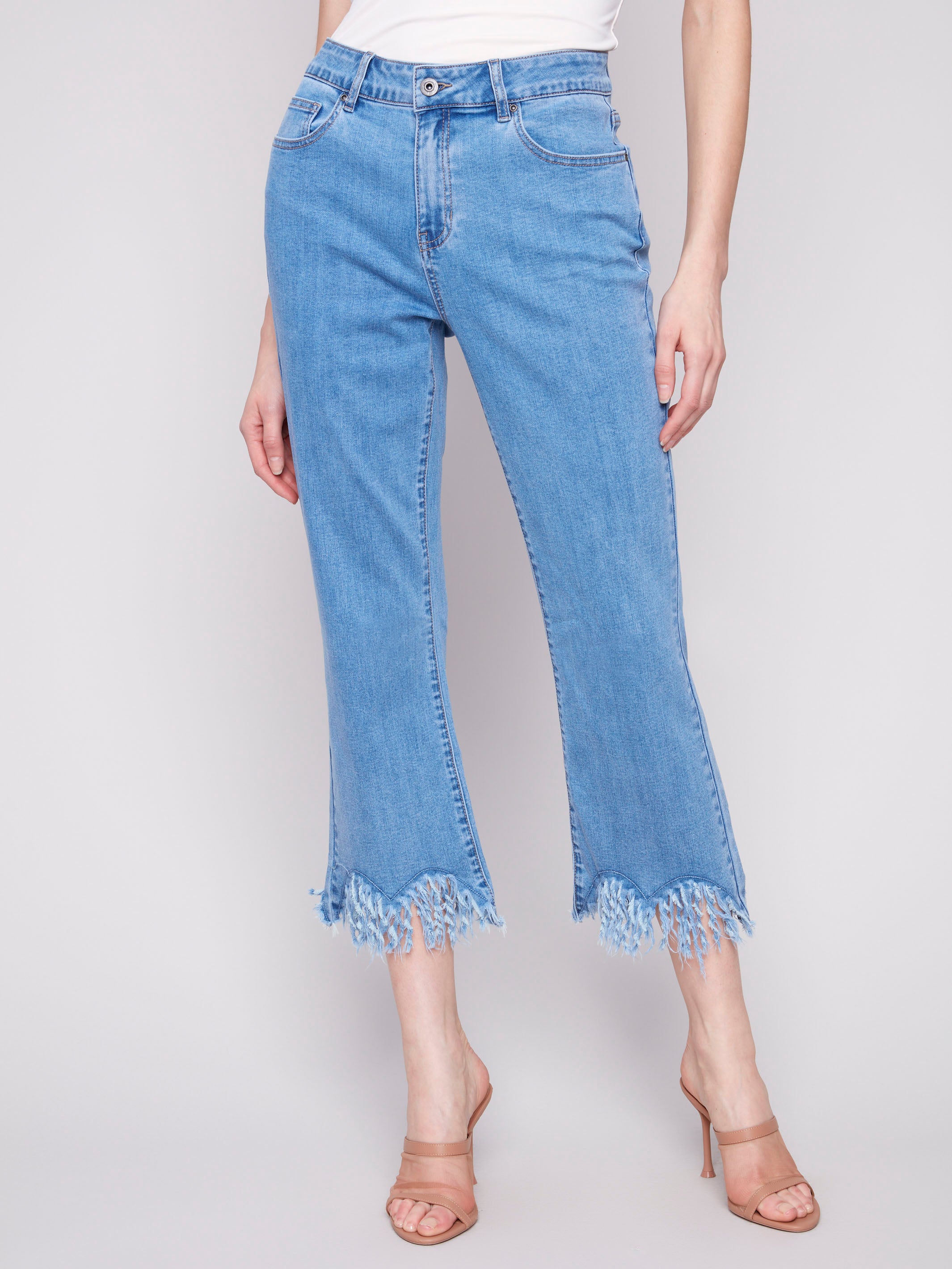 Blue cropped jeans with a fashionable fringed hem and bootcut leg design by Charlie B.