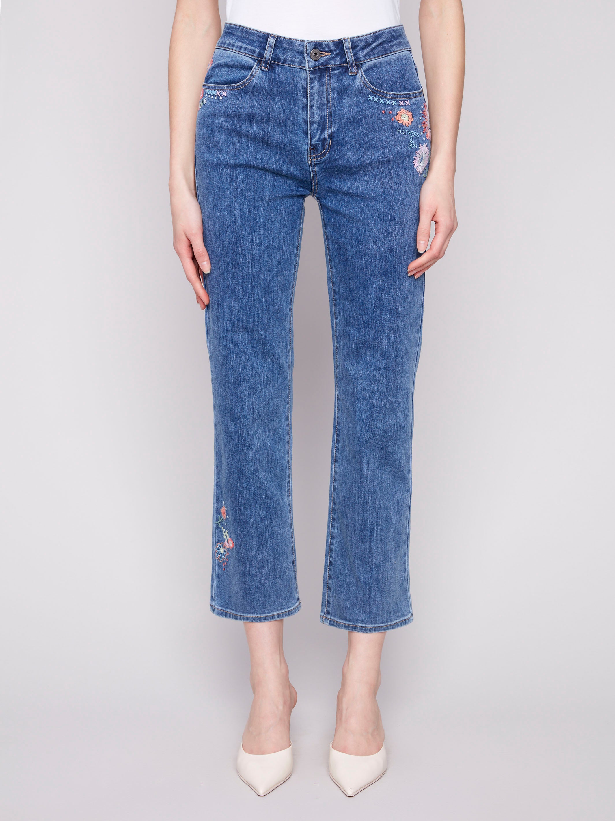 Ankle-length denim with floral embroidery accents by Charlie B.