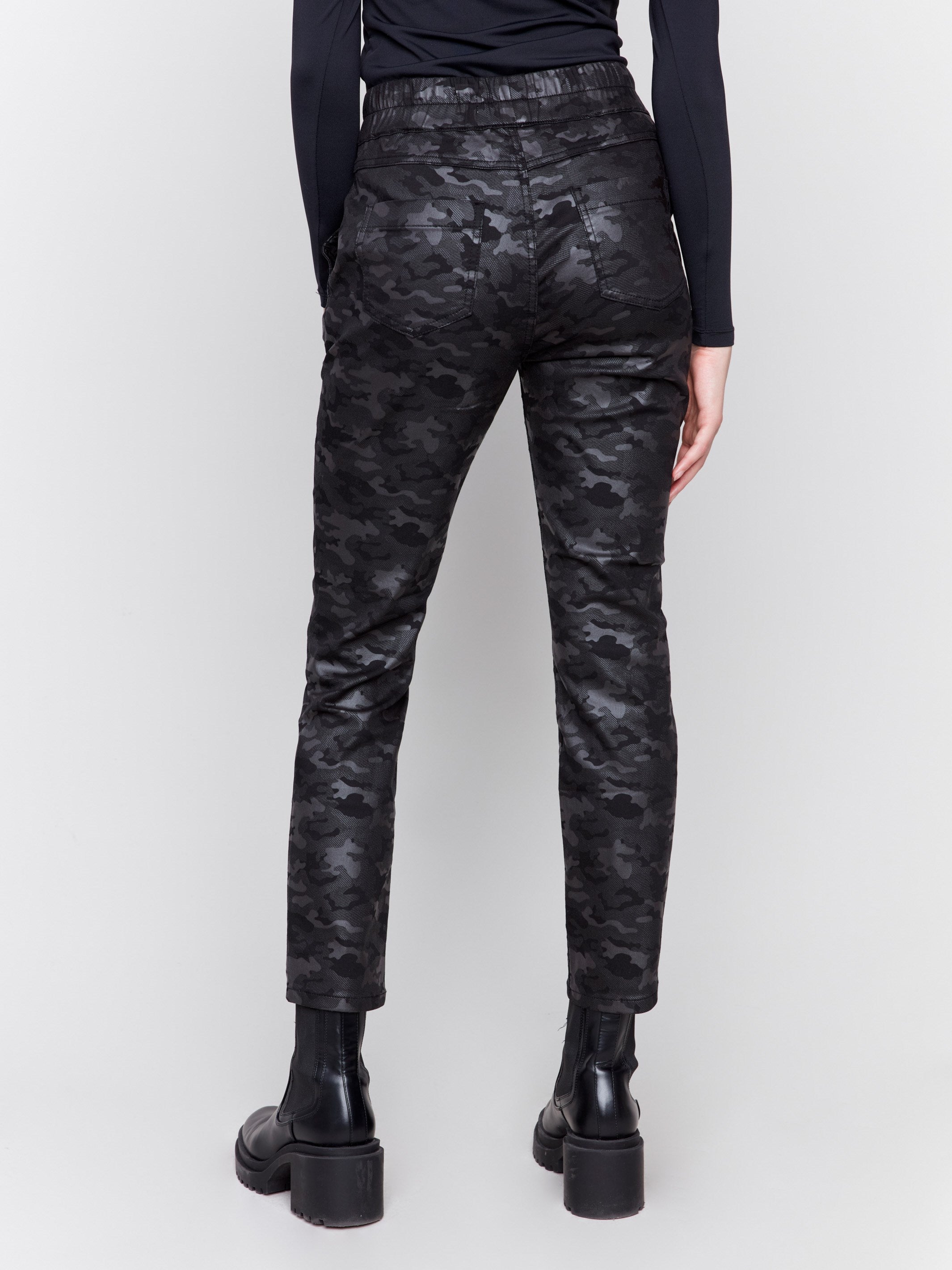 Black camouflage print jogger pants featuring slim legs, an elastic waistband with drawstring, and front pockets by Charlie B.