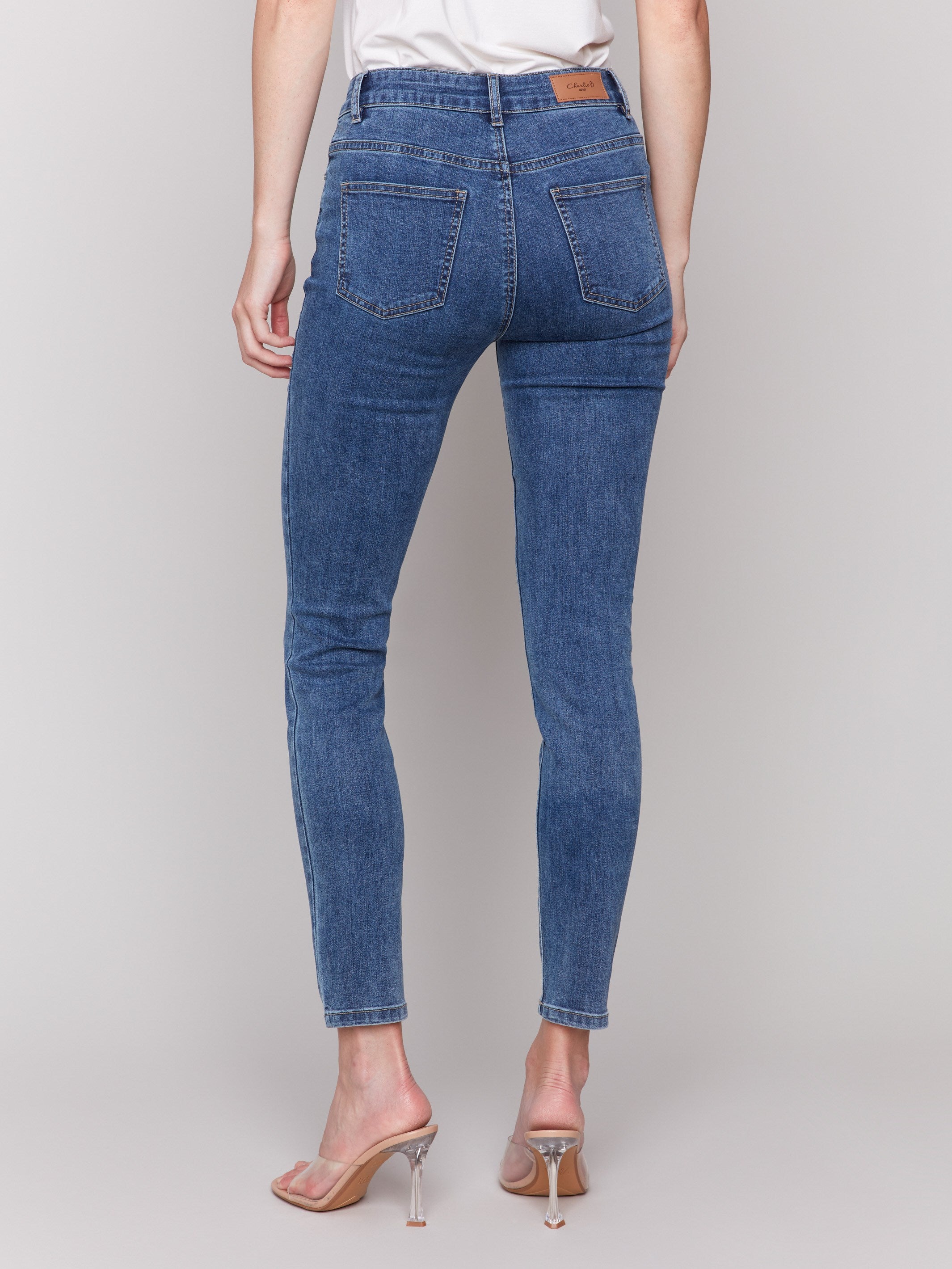 Medium blue skinny jeans featuring a five-pocket design by Charlie B, showcasing a sleek and stylish fit.