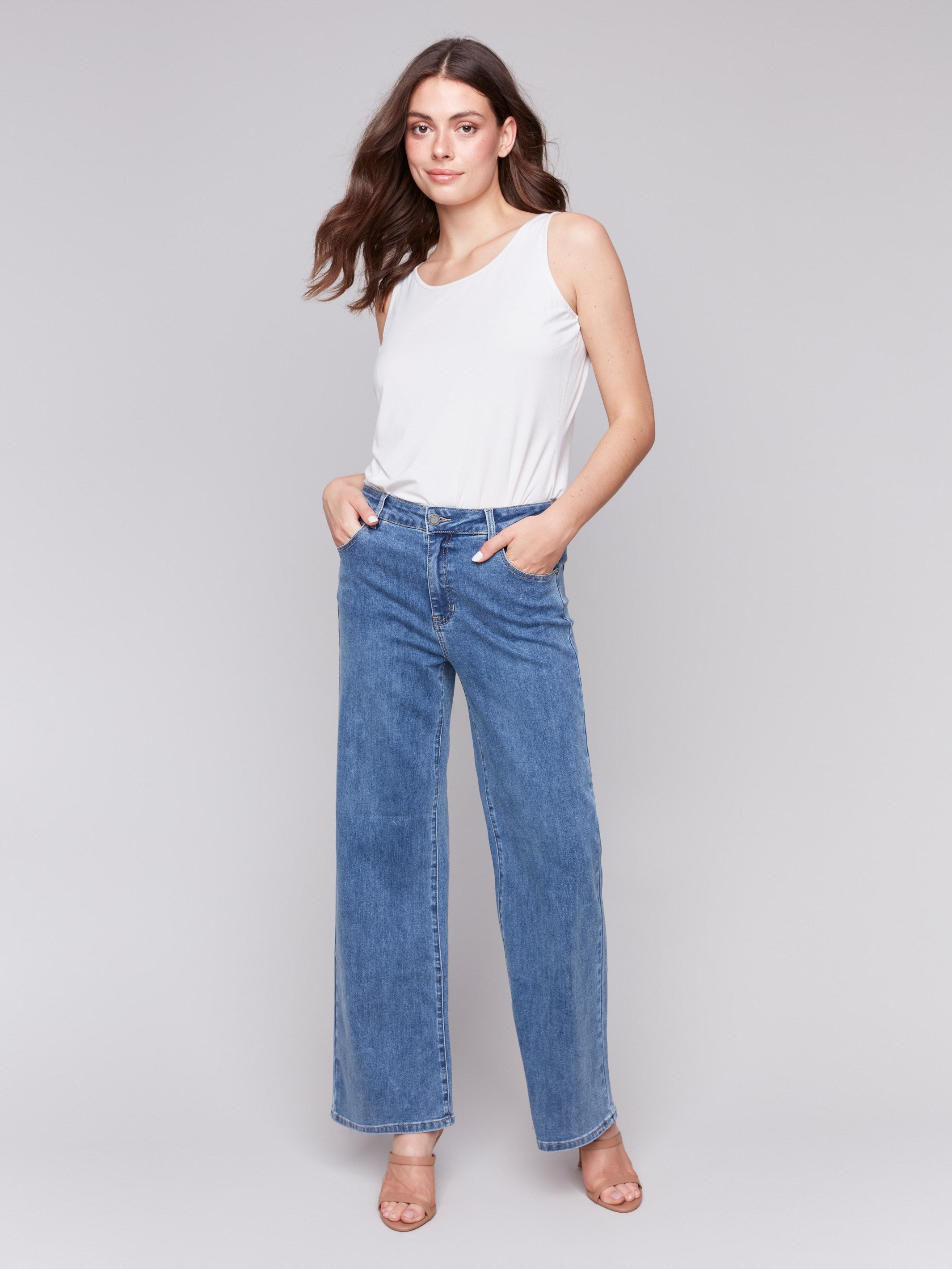 Medium blue wide-leg jeans with five-pocket design featuring a button closure and relaxed fit by Charlie B.