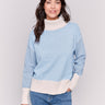 Light blue turtleneck sweater with color block design, featuring long sleeves and ribbed cuffs by Charlie B.