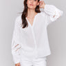 White blouse featuring a V-neck design by Charlie B.