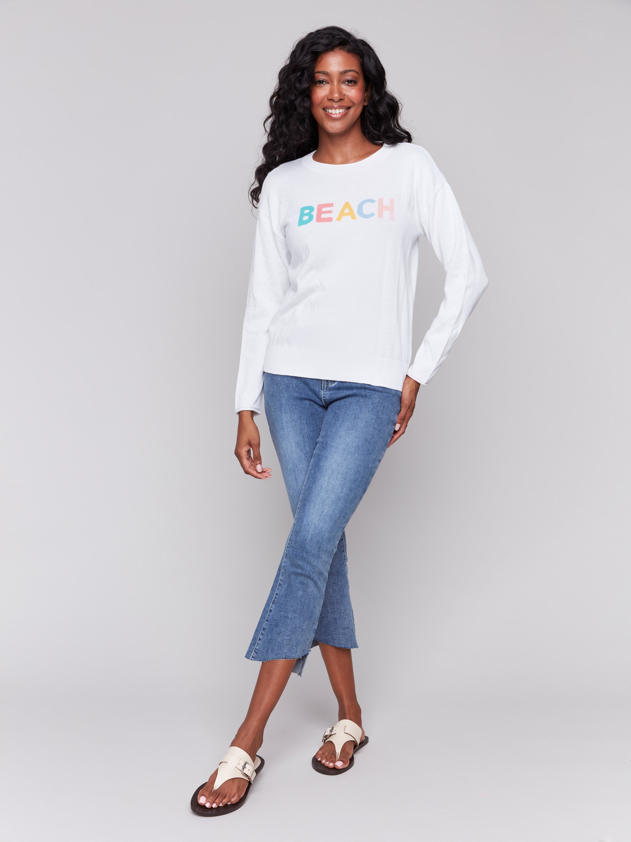 Stylish white sweater featuring a colorful 'BEACH' graphic by Charlie B.