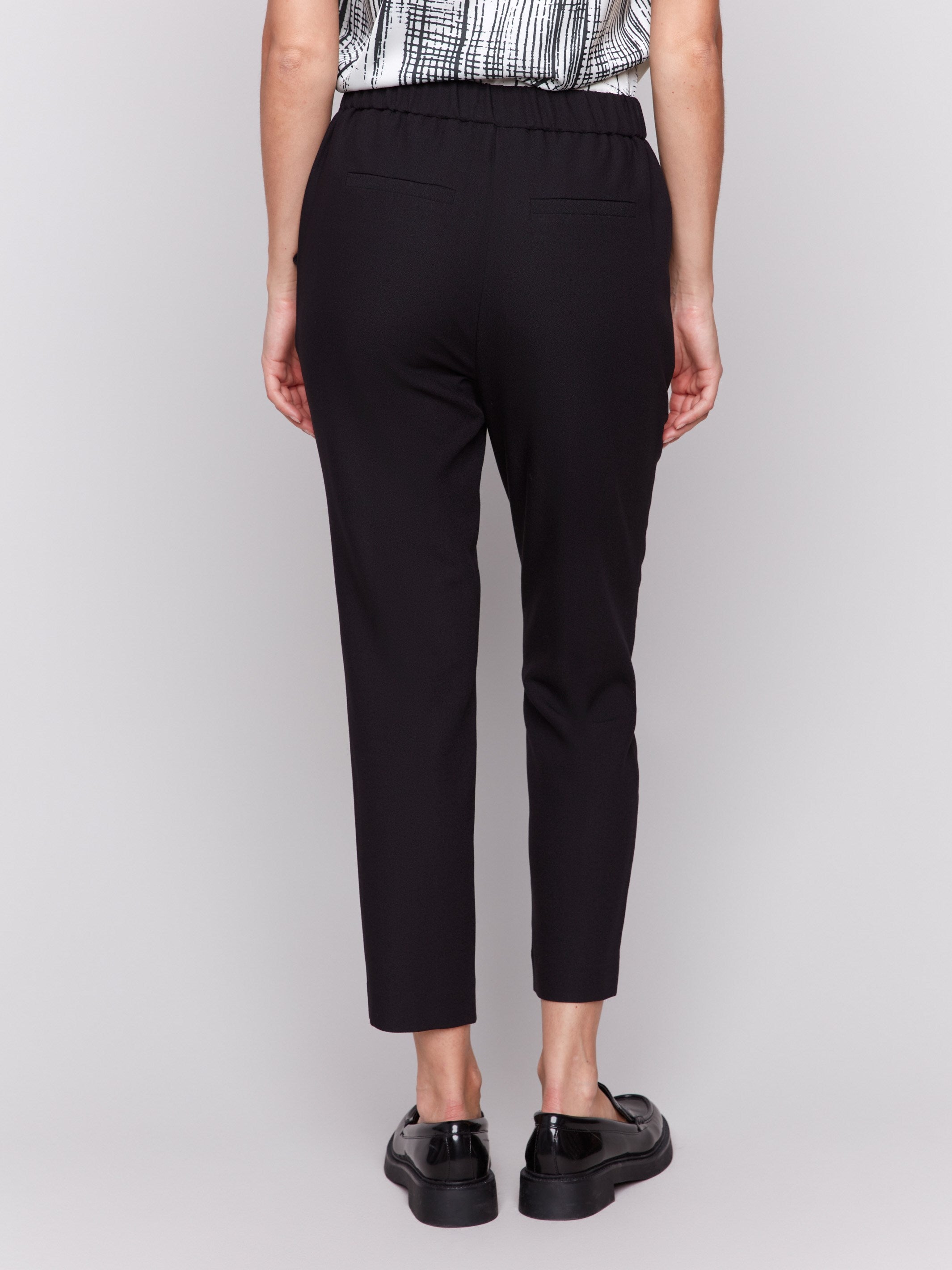 Black cropped crepe pants with side pockets and a slim leg design by Charlie B.