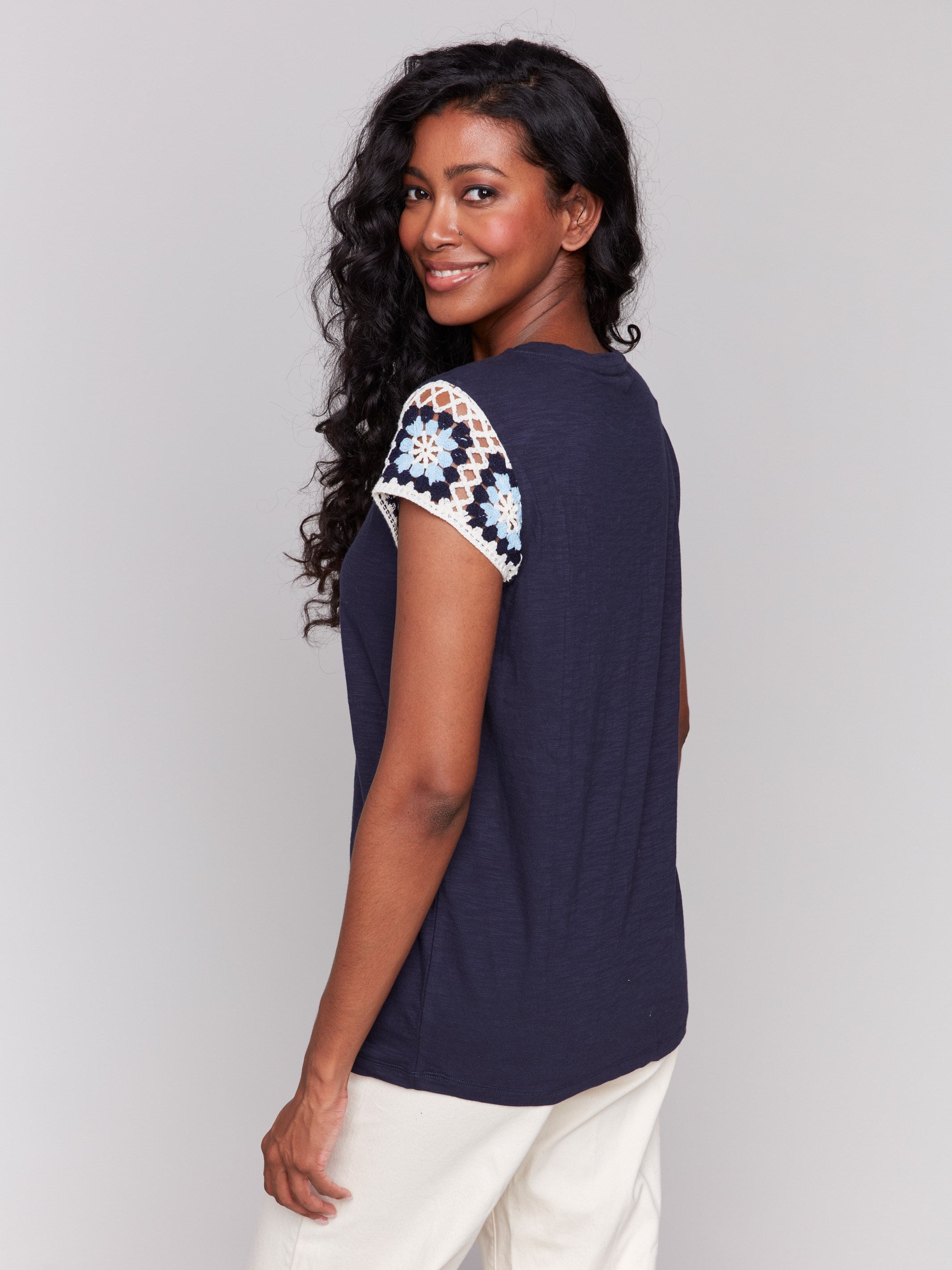 Stylish navy t-shirt with intricate crochet detailing on the sleeves by Charlie B.