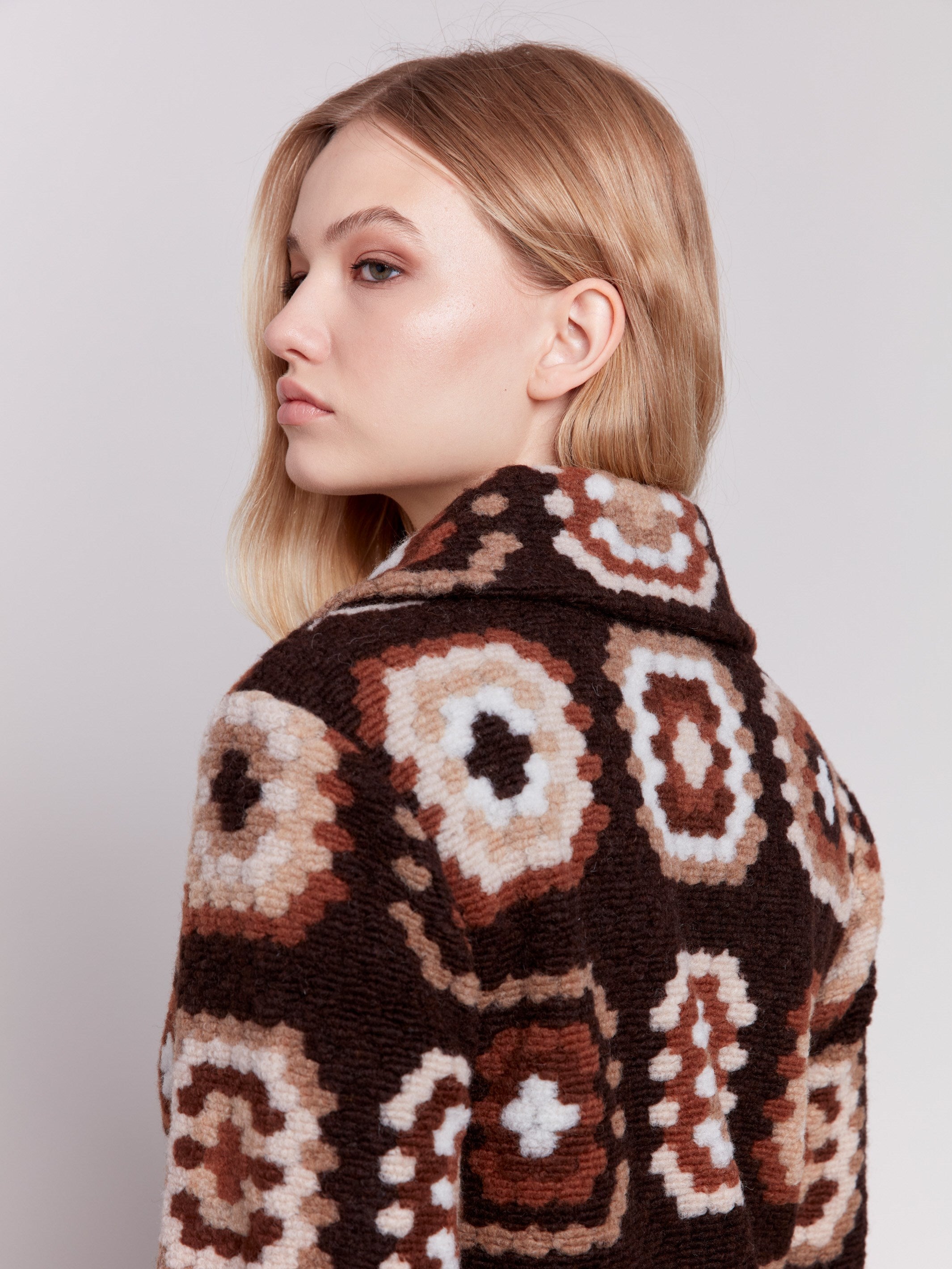 Chocolate crochet coat with colorful geometric patterns, featuring a front button closure and side welt pockets by Charlie B.