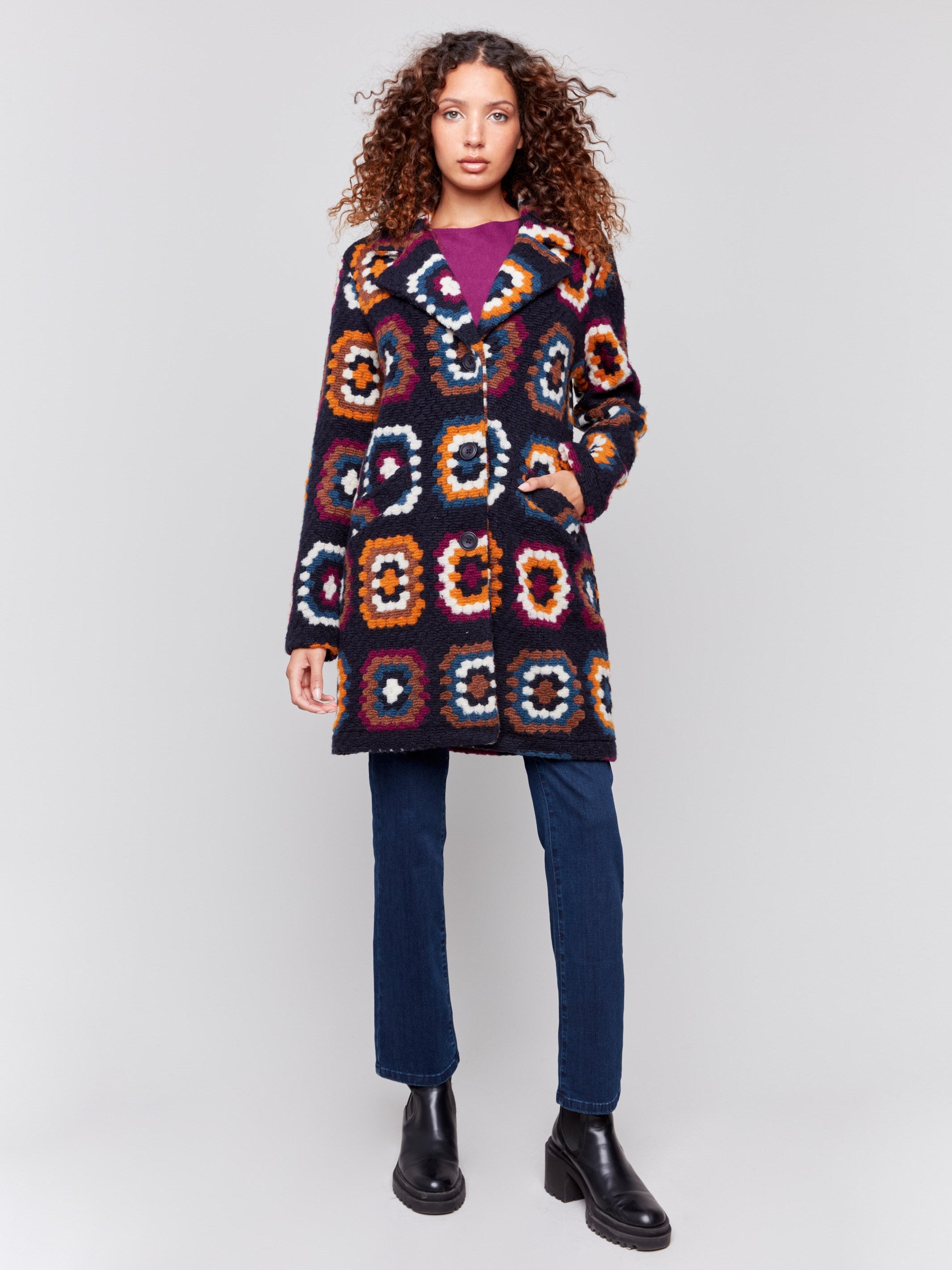 Navy blue crochet coat with colorful geometric patterns, featuring a front button closure and side welt pockets by Charlie B.