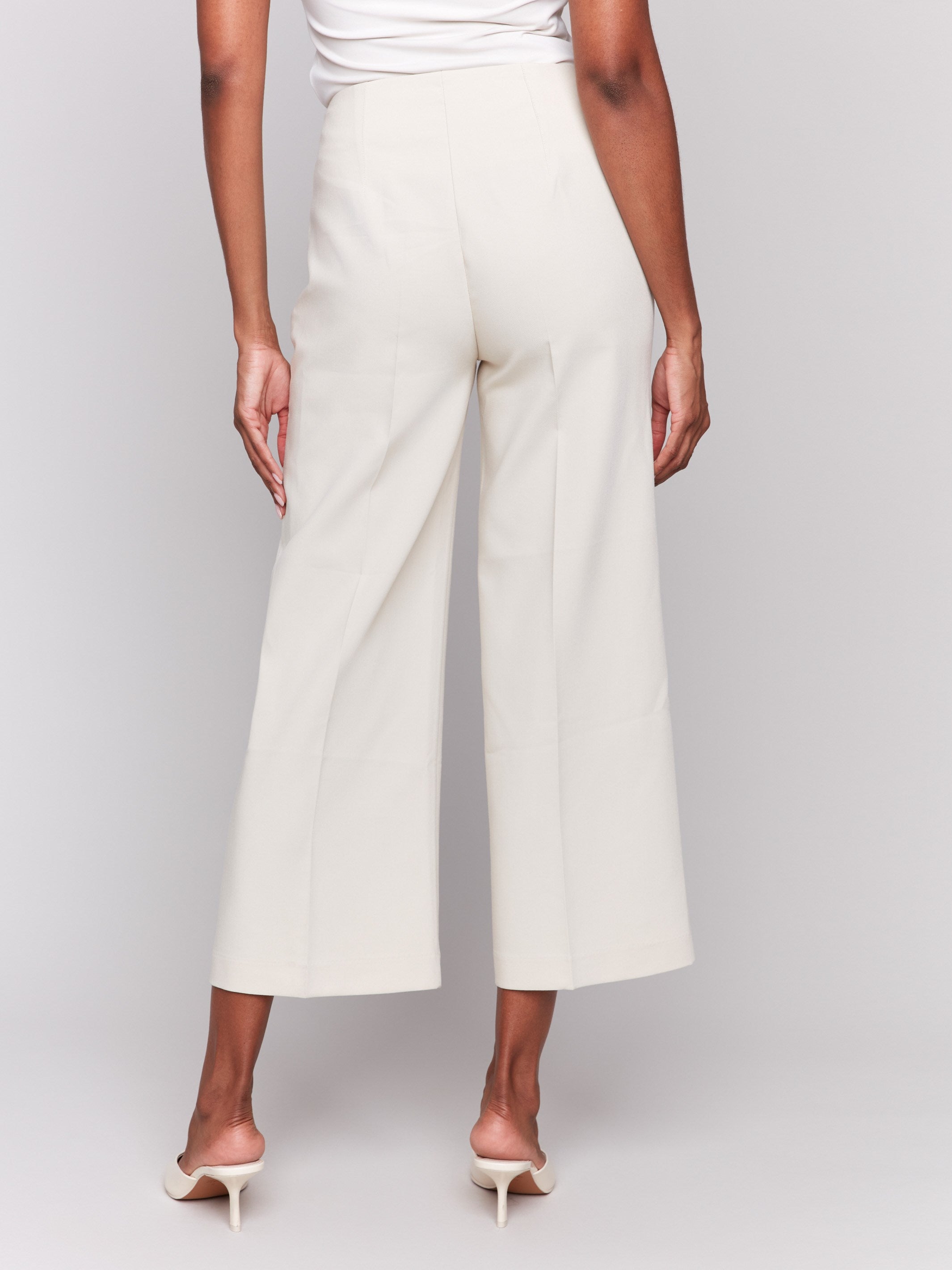 Beige cropped wide-leg pants with a side zipper, styled with a white top and beige heels by Charlie B.