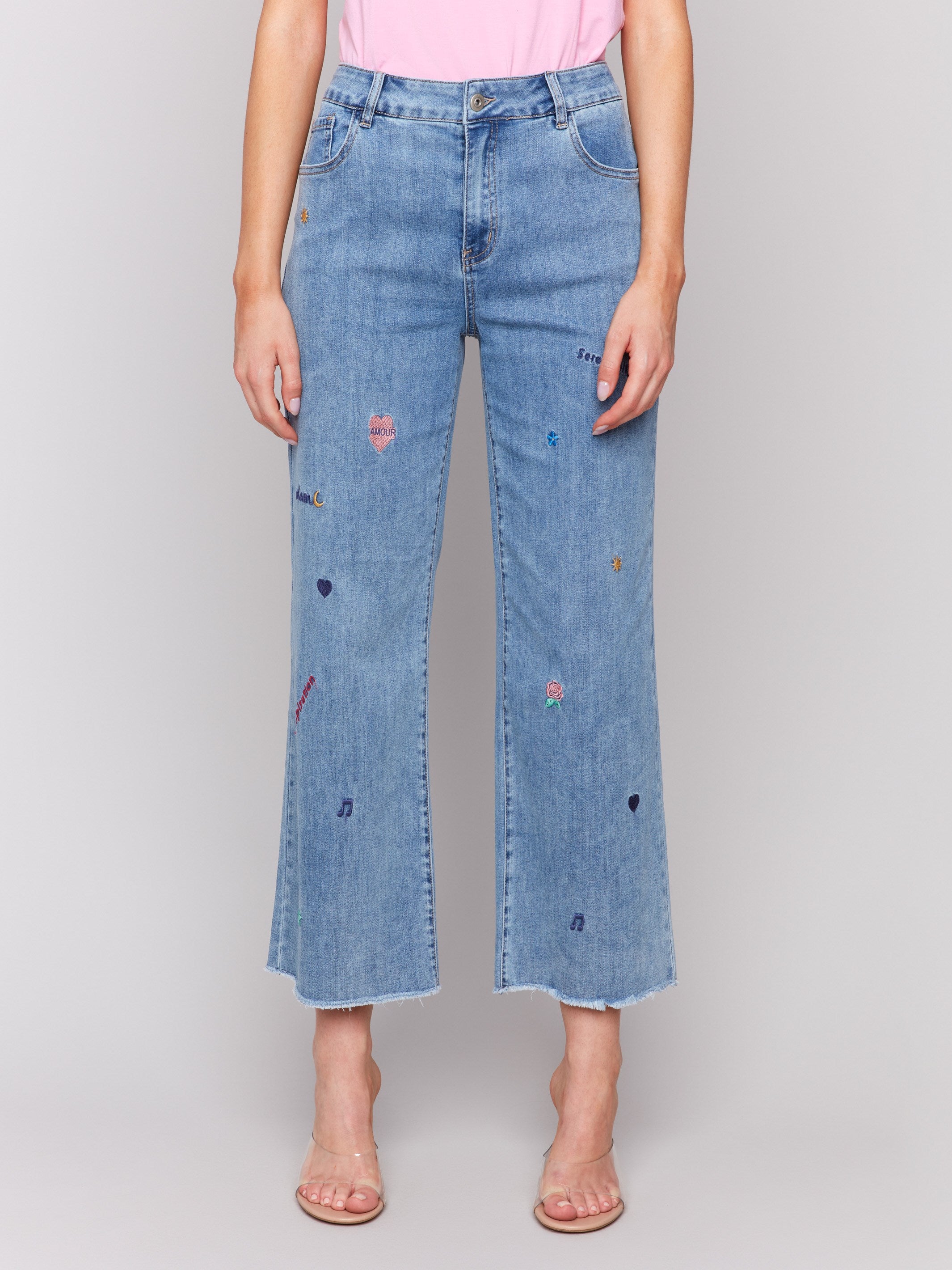 Medium blue flare leg jeans with embroidery and frayed hem by Charlie B.