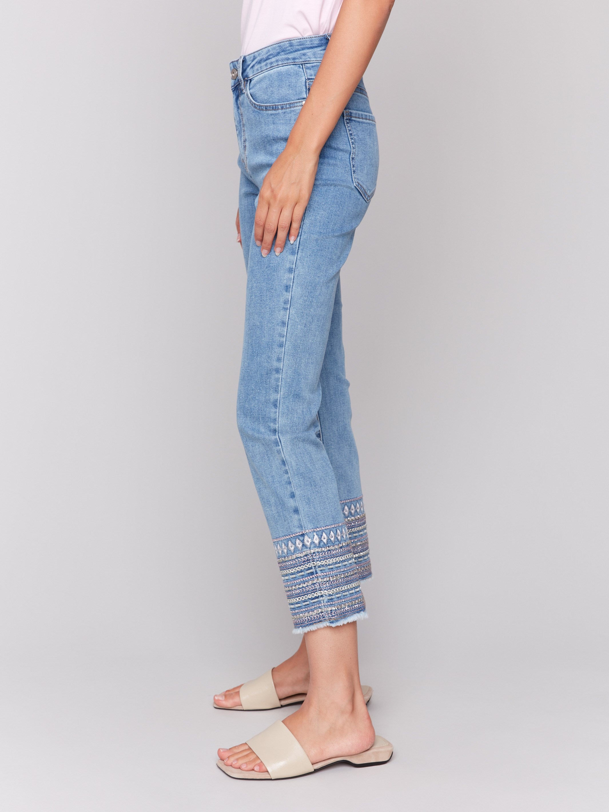 Light blue denim jeans with embroidered hems and a classic five-pocket design, featuring a slim fit by Charlie B.