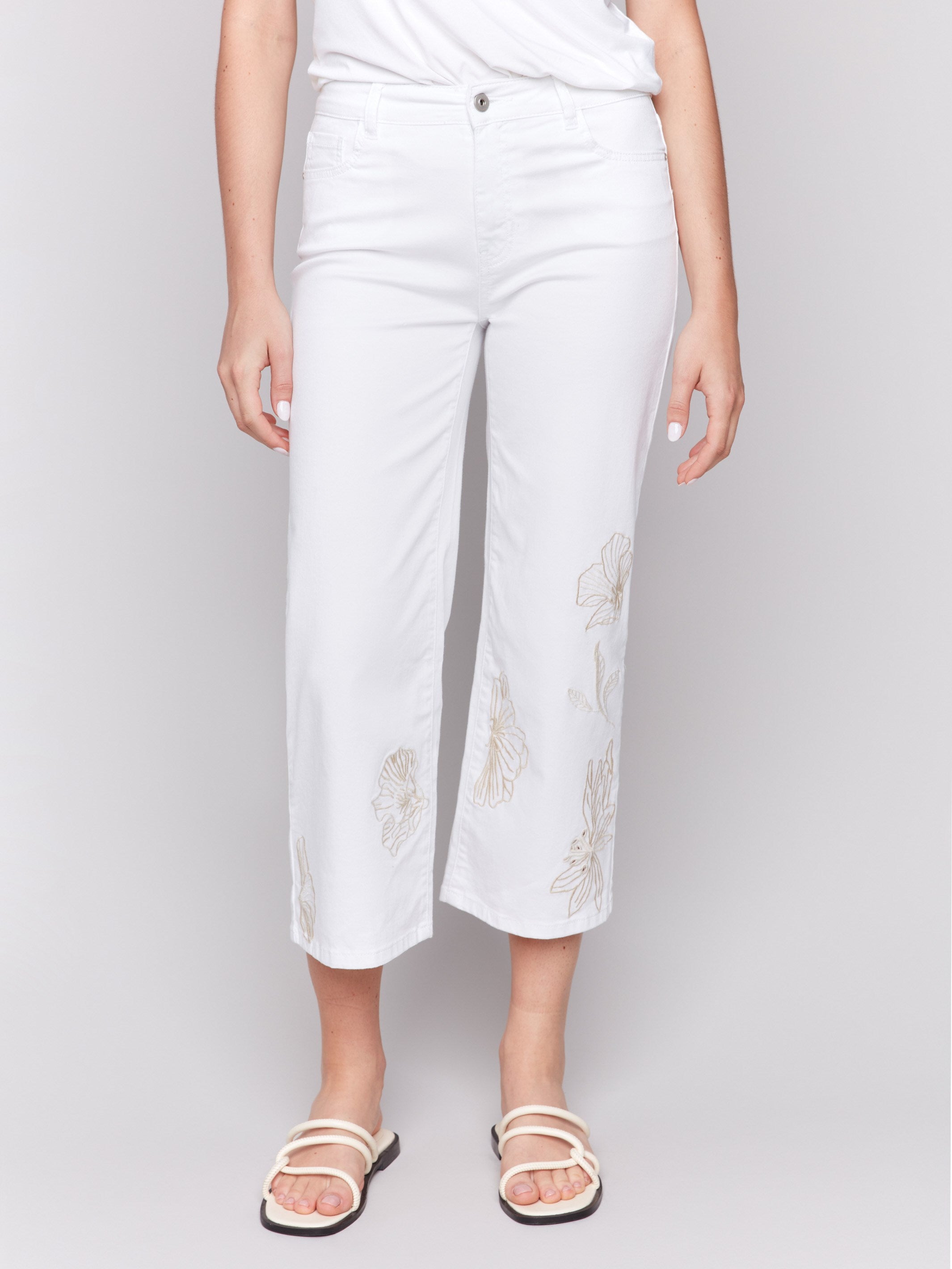 Floral embroidery accents on regular rise white pants by Charlie B.