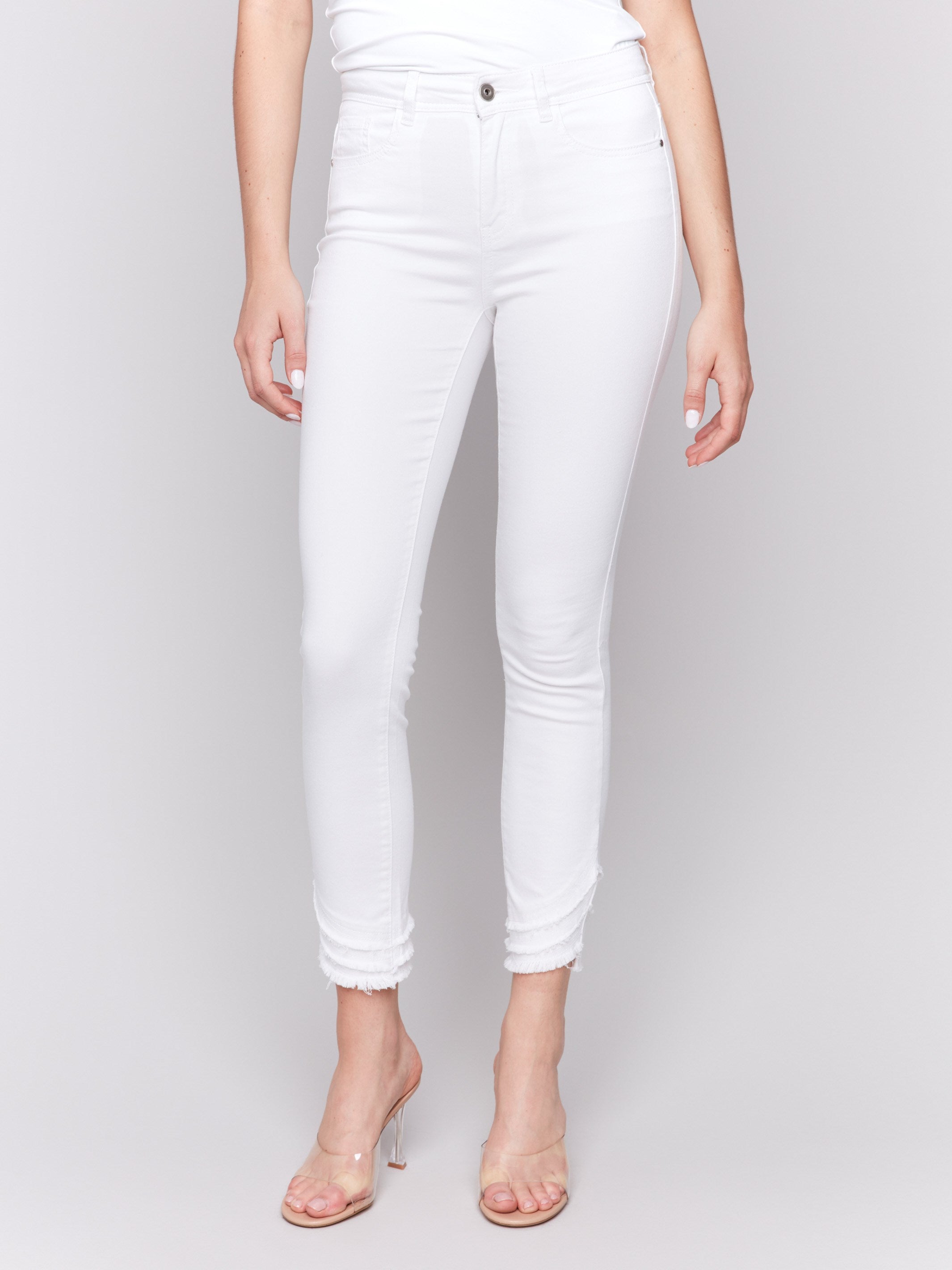 White slim fit twill pants with a frayed hem, ankle-length and mid-rise design by Charlie B.