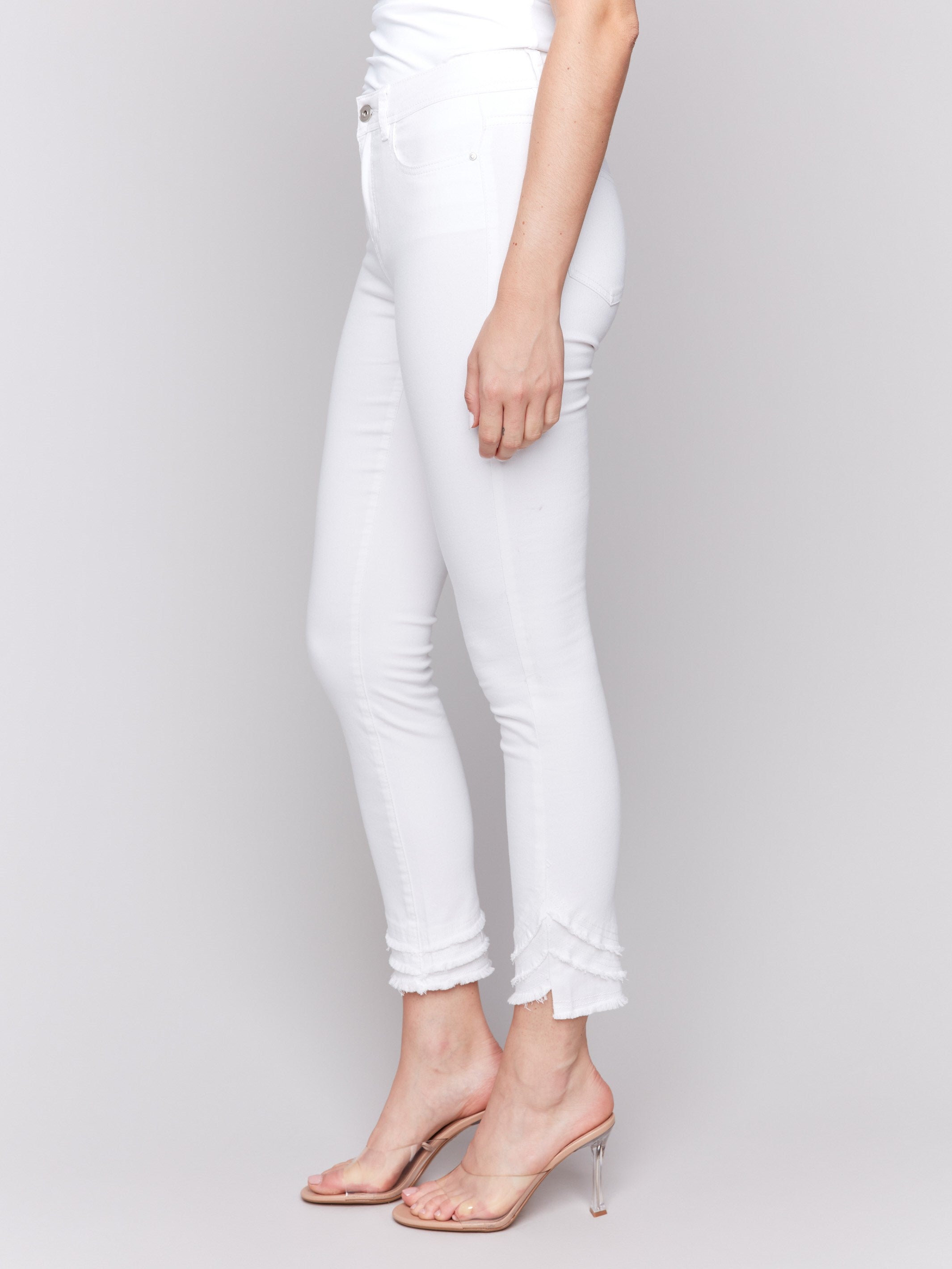 White slim fit twill pants with a frayed hem, ankle-length and mid-rise design by Charlie B.