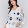 Blue crochet top with 3/4 sleeves, featuring a vibrant floral pattern by Charlie B.