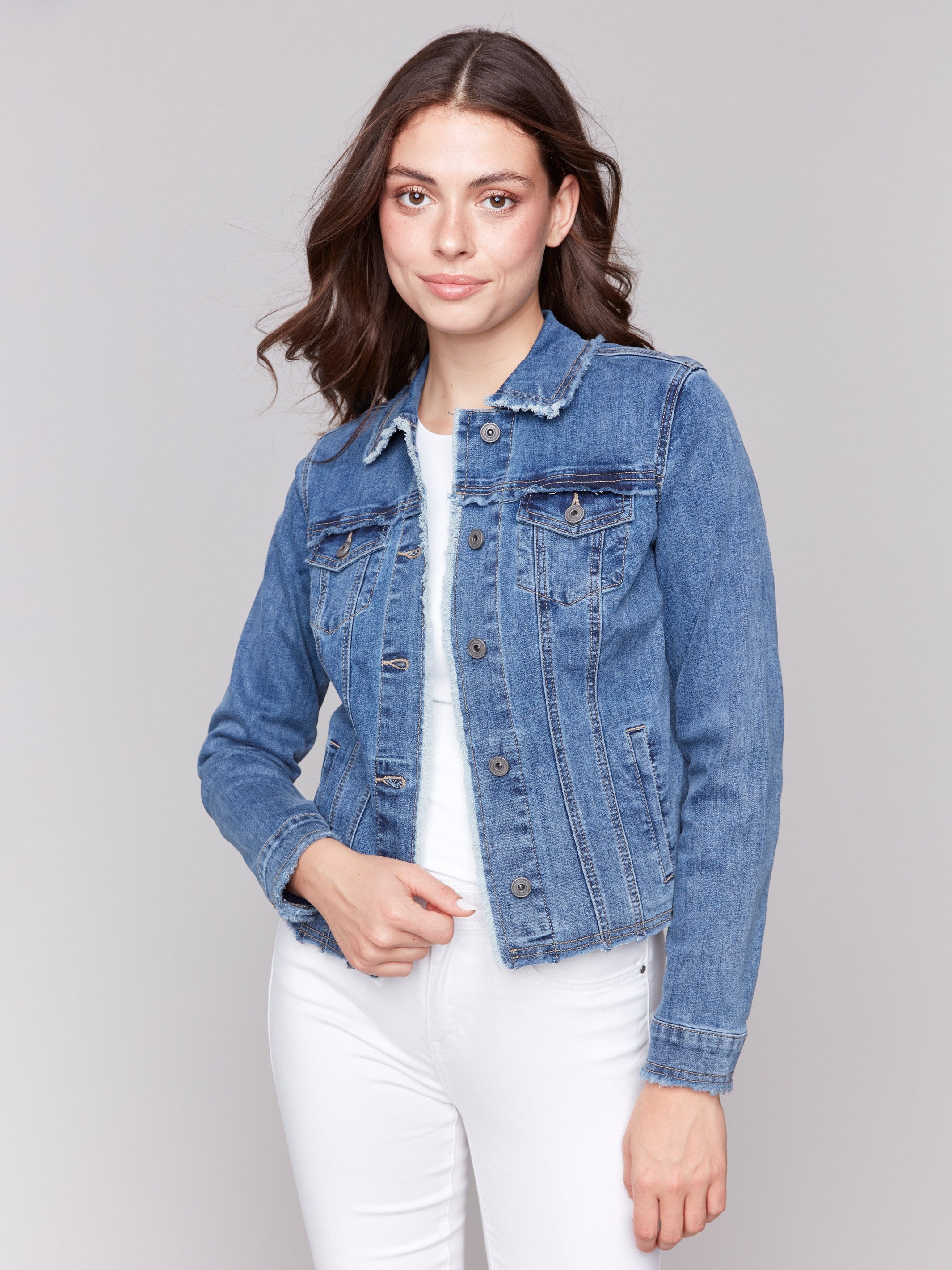 Medium blue denim jacket with frayed edges and front pockets by Charlie B.