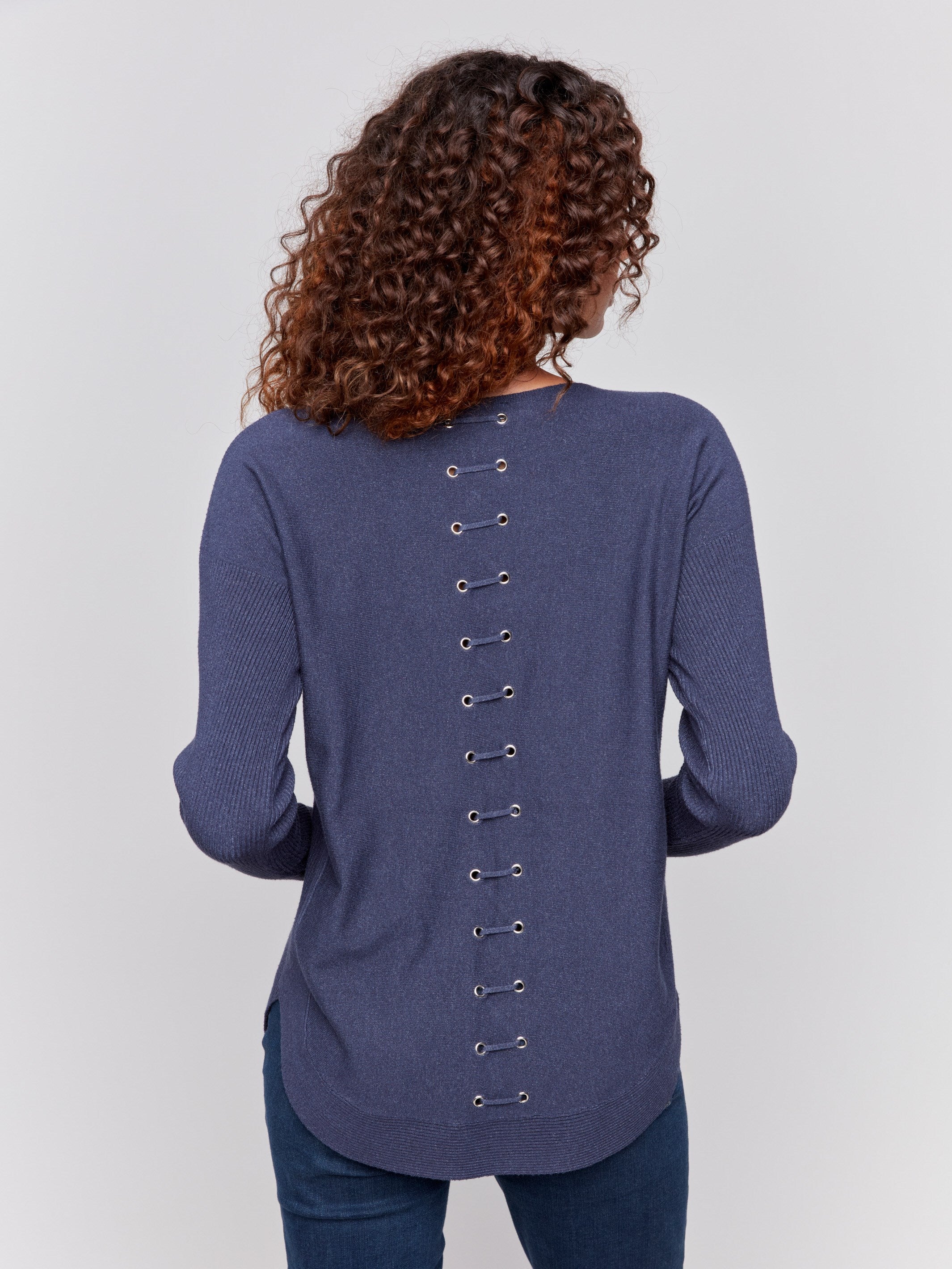 Dark blue knit sweater with a crew neckline, long ribbed sleeves, and back lace-up eyelet details by Charlie B.