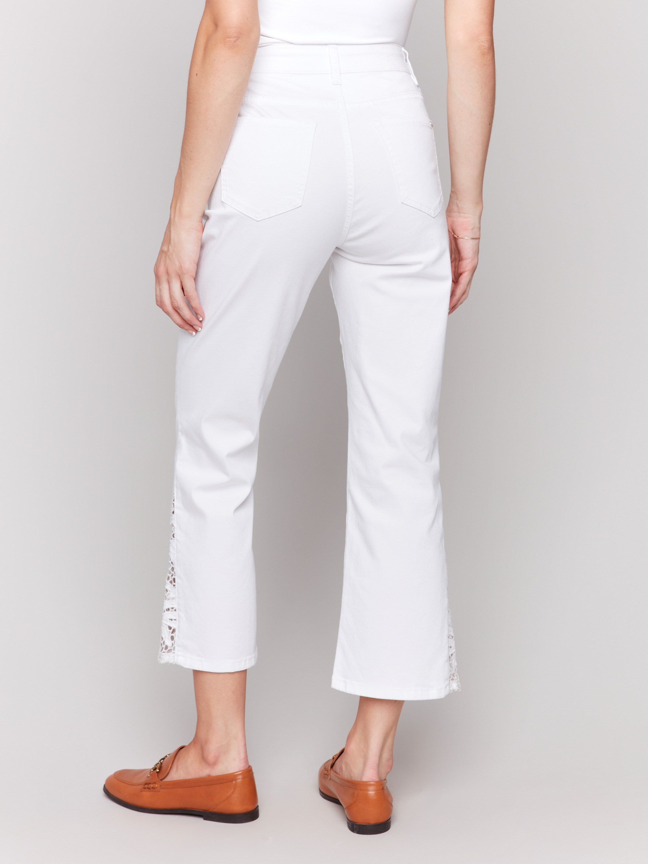 Elegant lace cut details on white bootcut ankle pants by Charlie B.