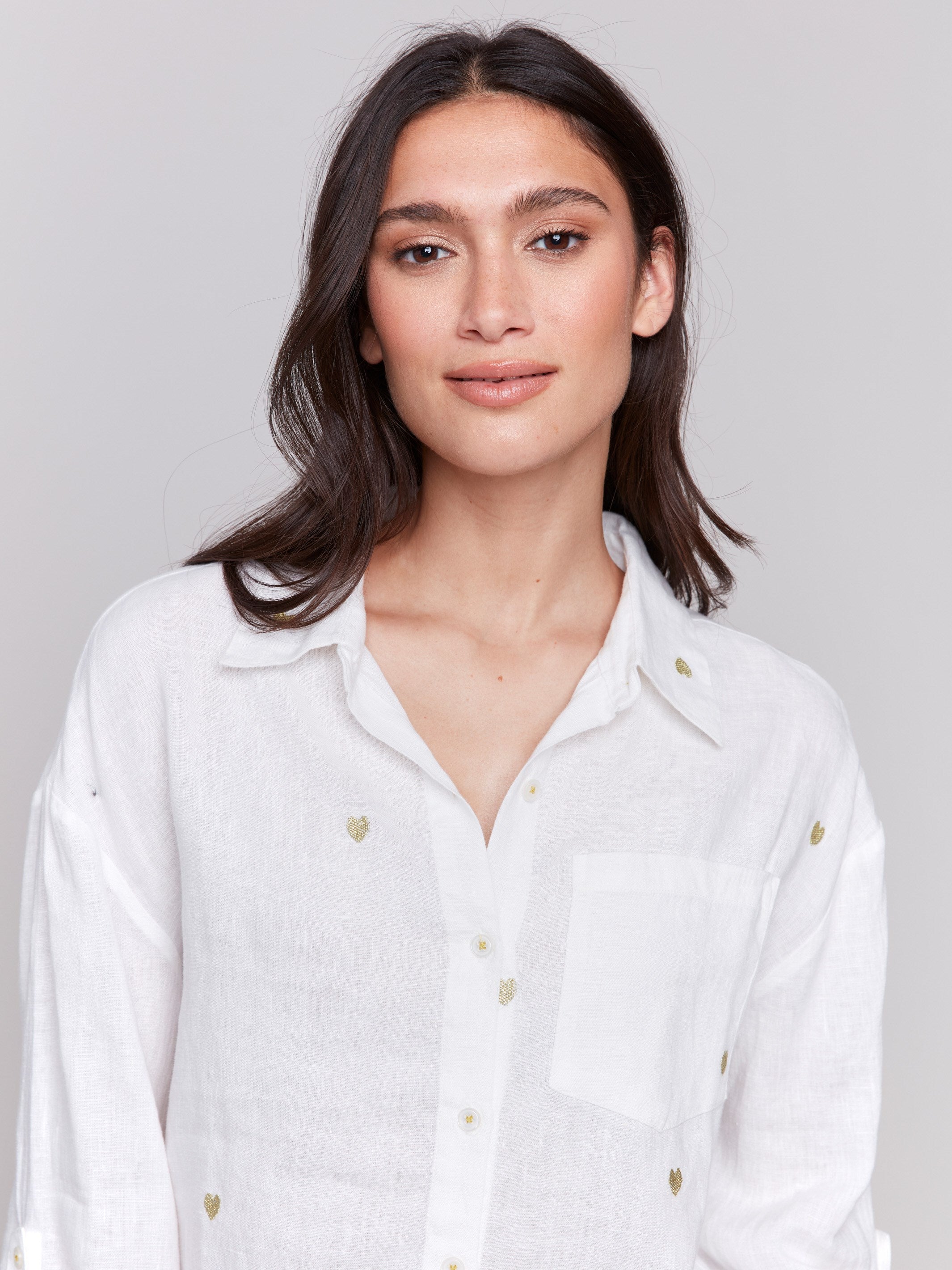 Gold linen tunic blouse with embroidered hearts, featuring a long button-down design, drop shoulders, and roll-up sleeves by Charlie B.