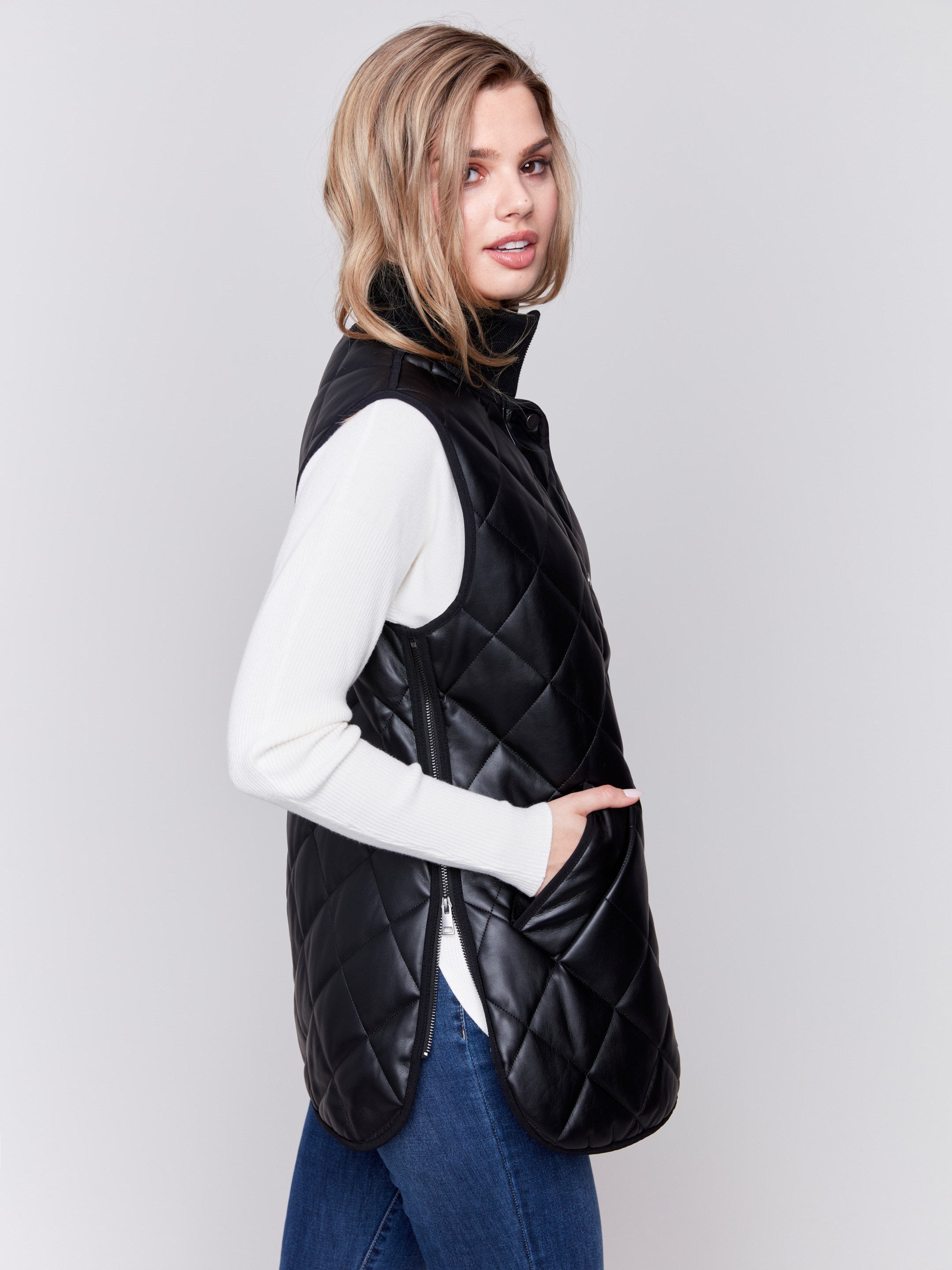 Black faux leather vest with quilted design, featuring a front zipper closure and side welt pockets, by Charlie B.