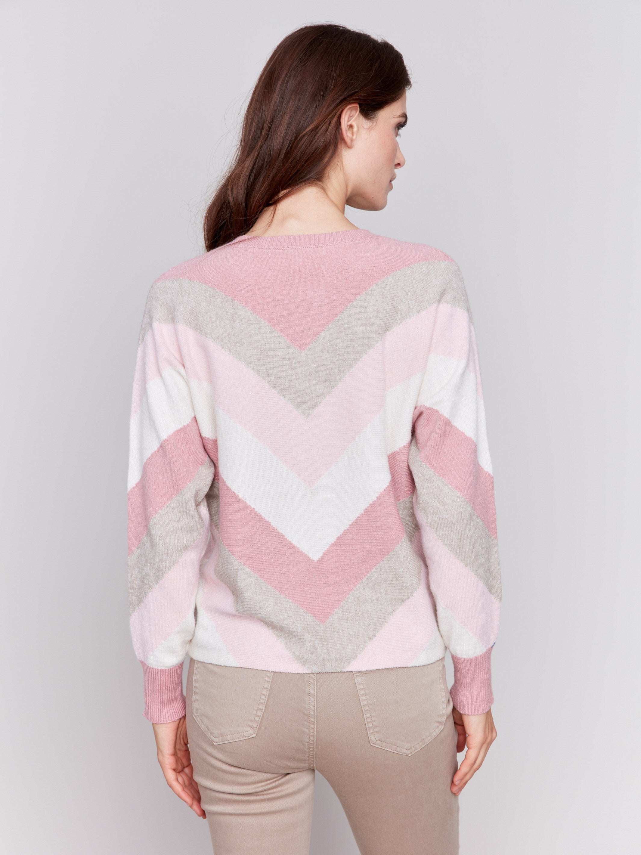 Woodrose-colored long-sleeve sweater with chevron stripes in pink, white, and beige. Crew neckline and ribbed cuffs by Charlie B.