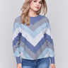 Denim-colored long-sleeve sweater with chevron stripes in blue, grey, and white. Crew neckline and ribbed cuffs by Charlie B.