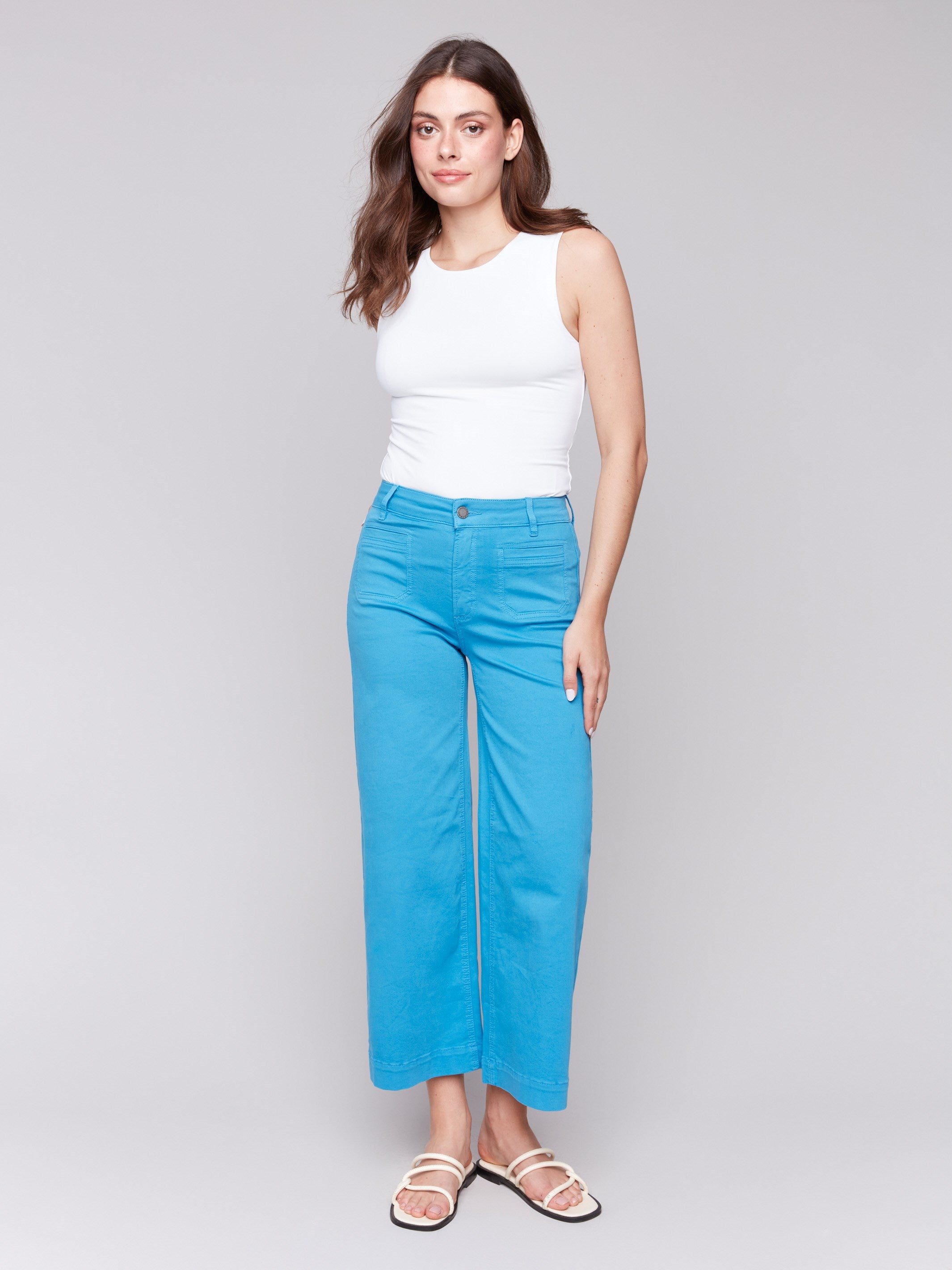 Blue flare twill pants featuring front patch pockets with a regular rise, button closure by Charlie B.