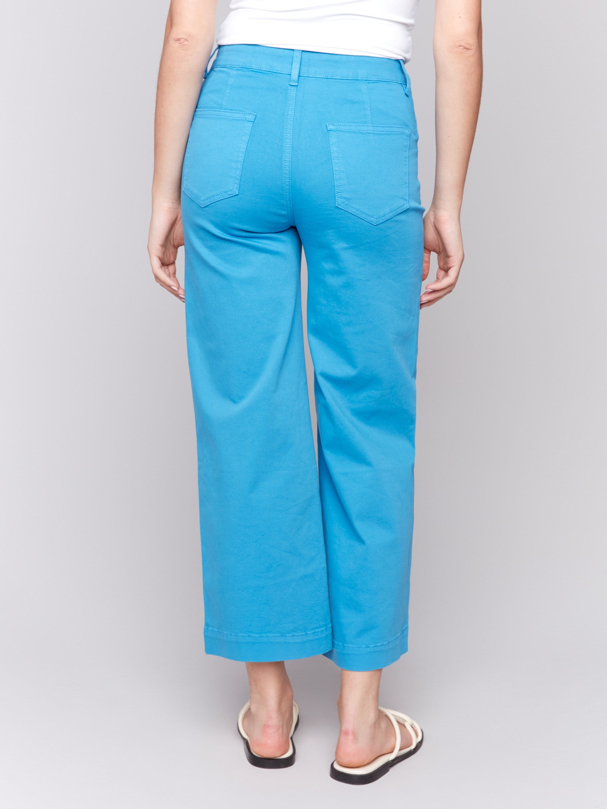 Blue flare twill pants featuring front patch pockets with a regular rise, button closure by Charlie B.