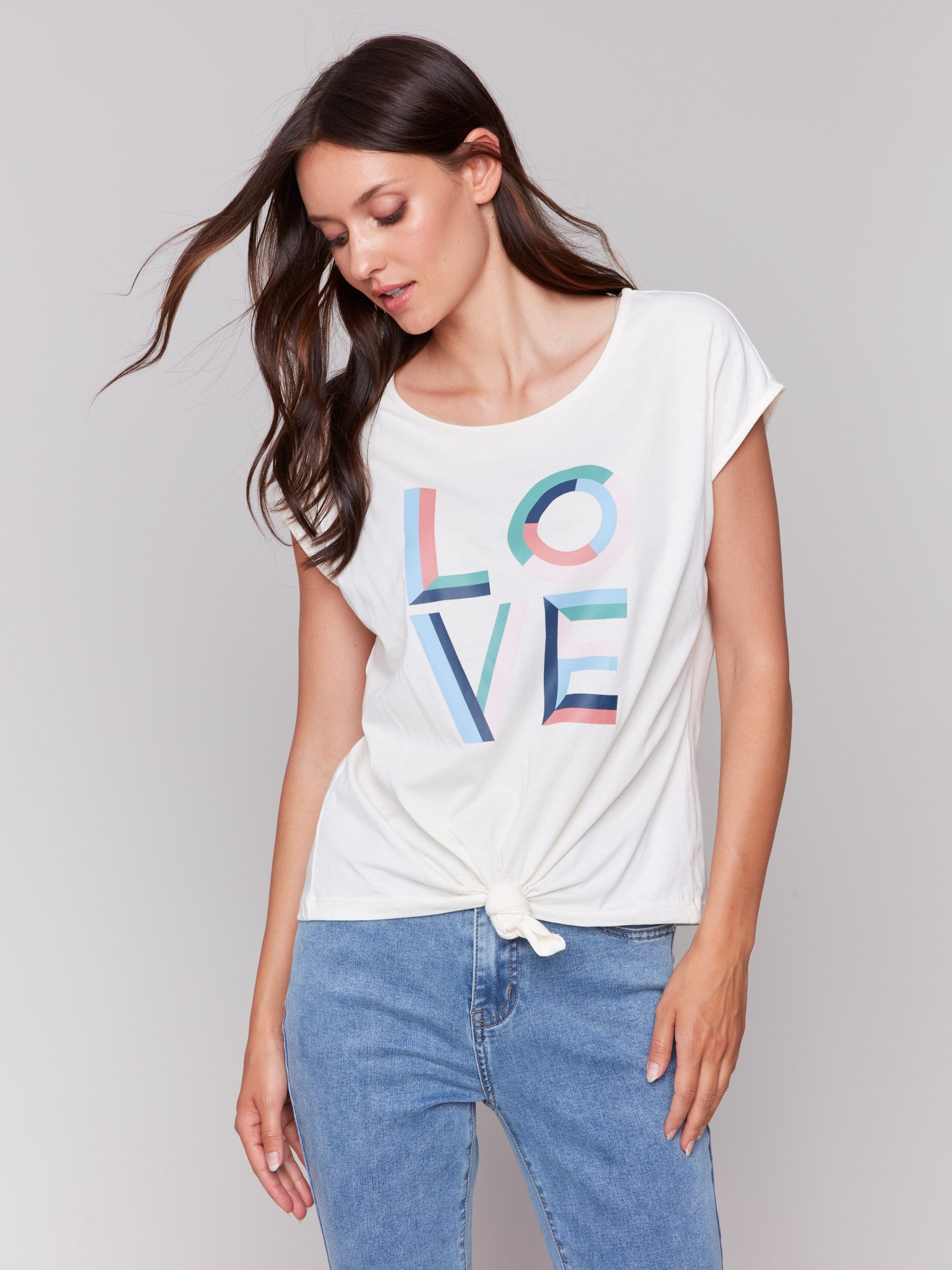 White sleeveless top with colorful 'LOVE' graphic print and a front-knot design by Charlie B.