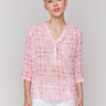 Geometric pattern blouse with a half-button front and vibrant colors by Charlie B.