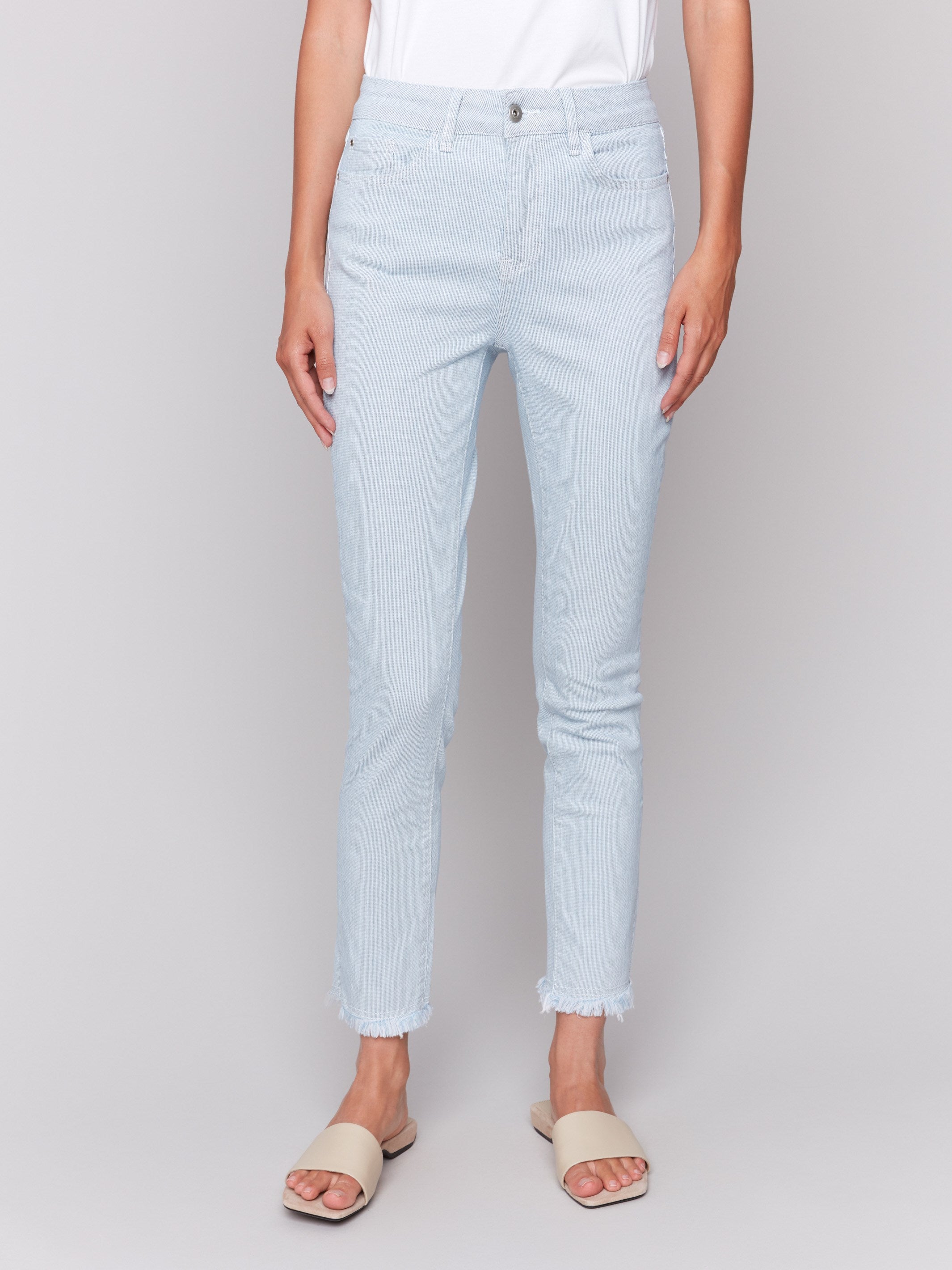 Light blue twill pants with subtle stripe pattern, featuring a slim leg silhouette and a slit at the hem by Charlie B.