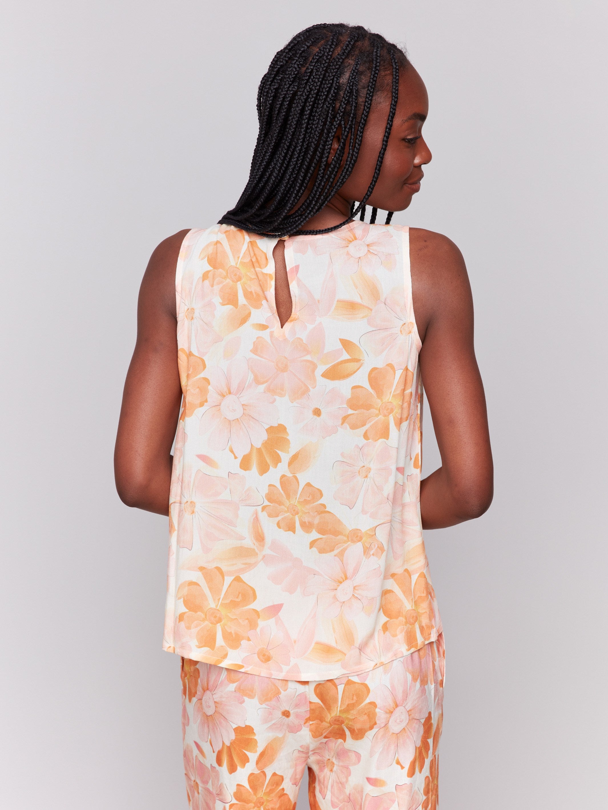 Elegant sleeveless design with a charming floral motif and round neckline by Charlie B.