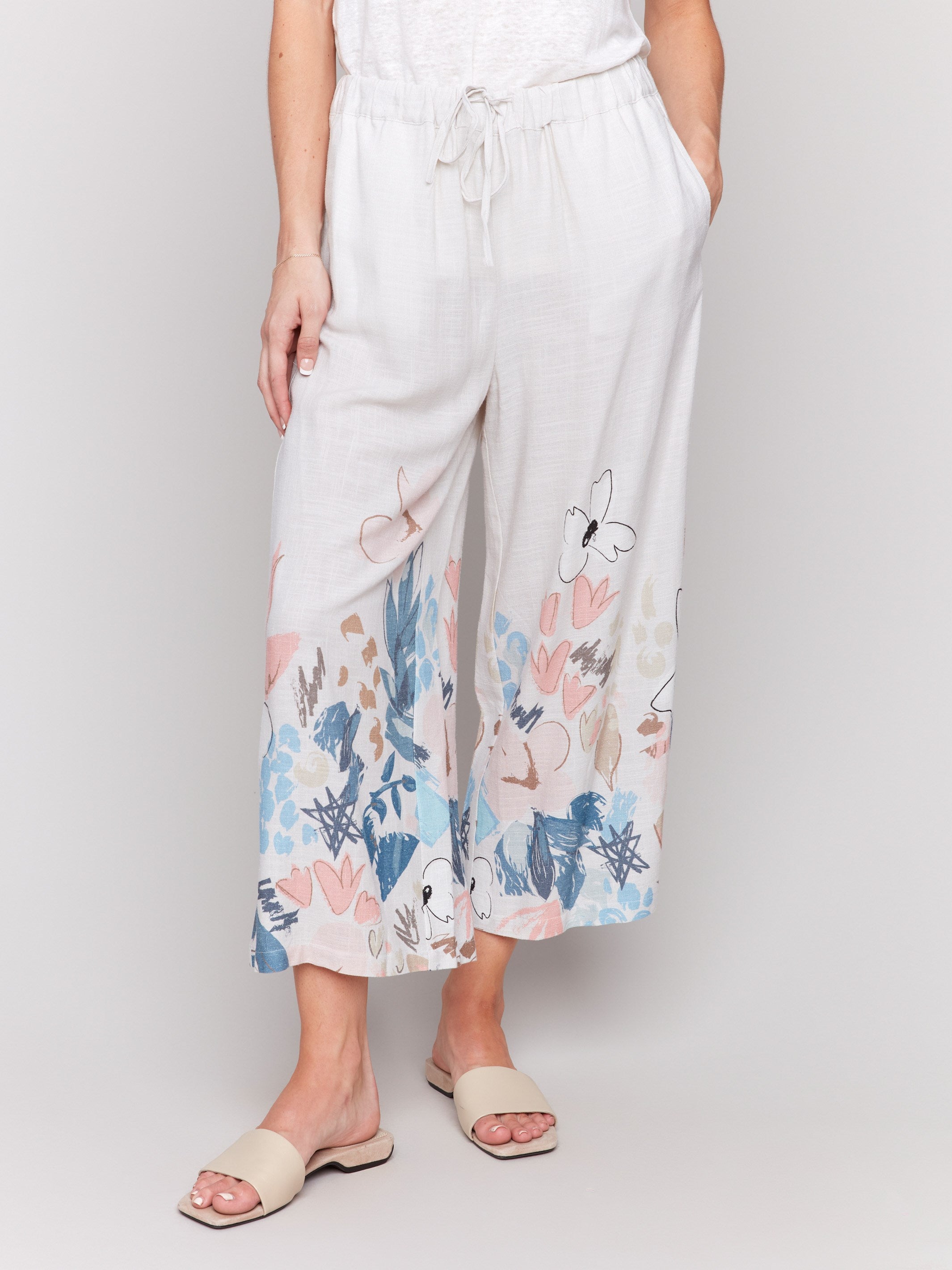 Cropped linen pants with a vibrant floral pattern and in-seam pockets by Charlie B.