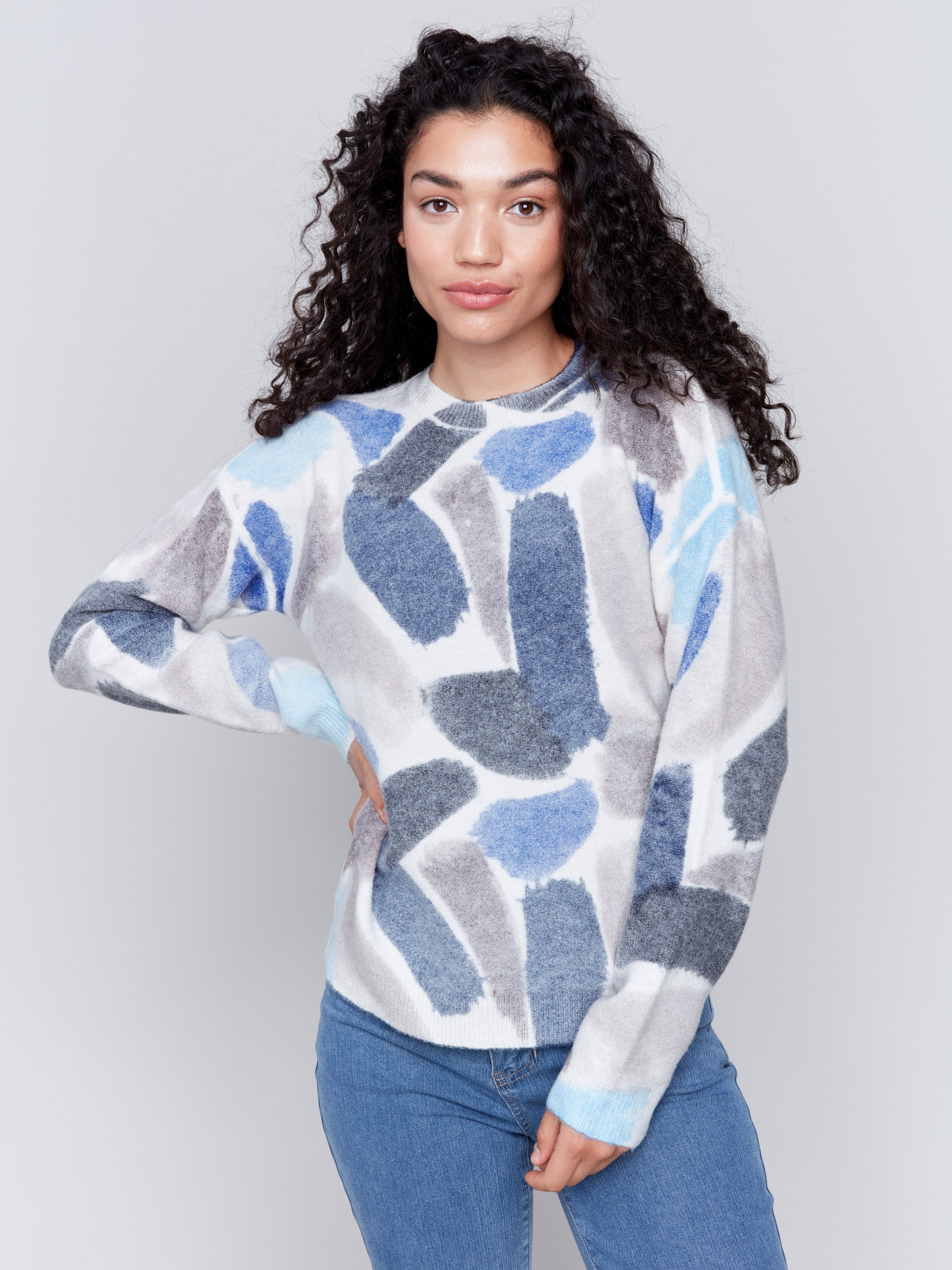 Woman wearing a reversible sweater with sapphire blue abstract prints and a crew neckline by Charlie B.