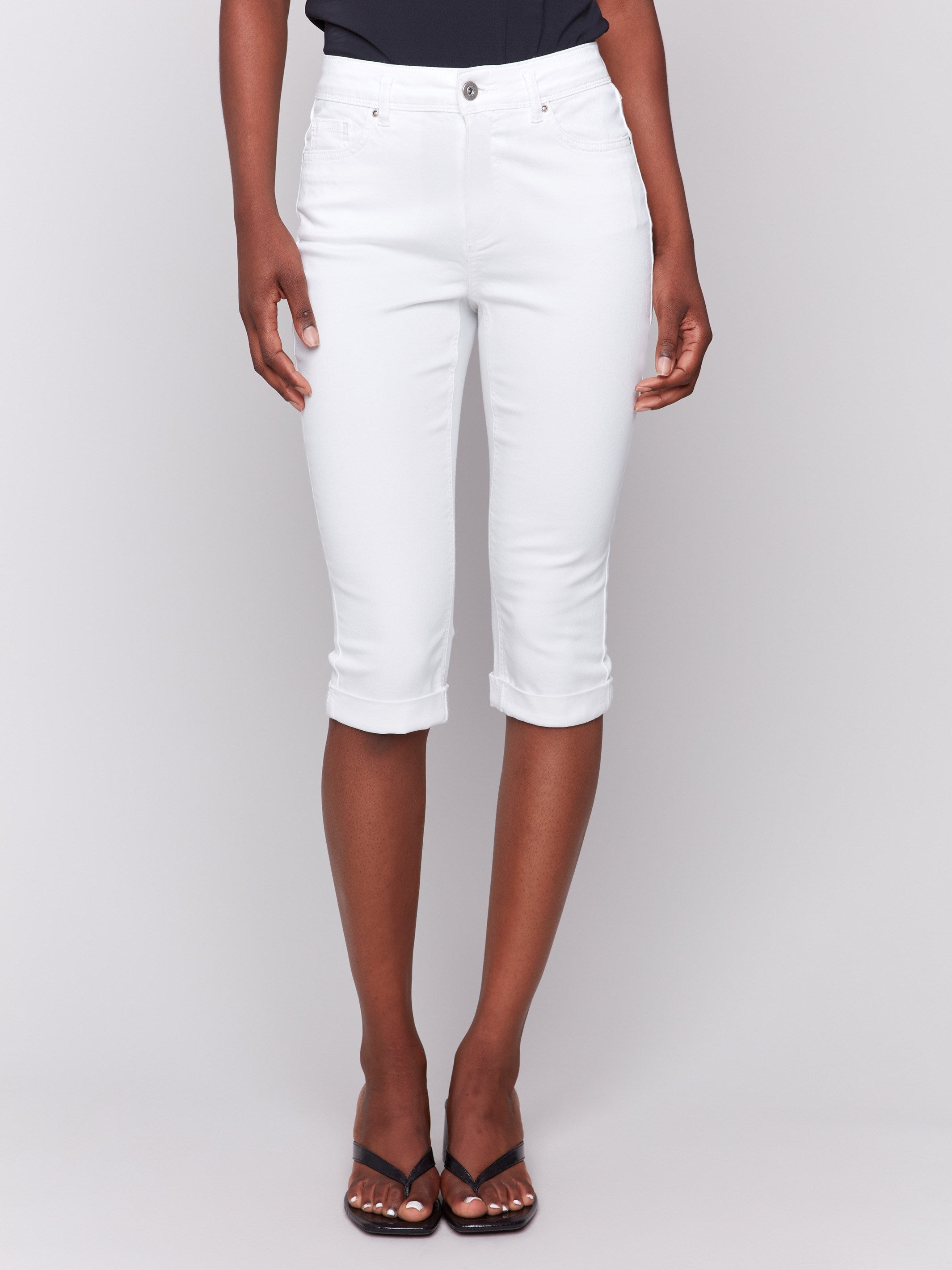 Cropped length white pedal pusher pants featuring a classic five-pocket design by Charlie B.