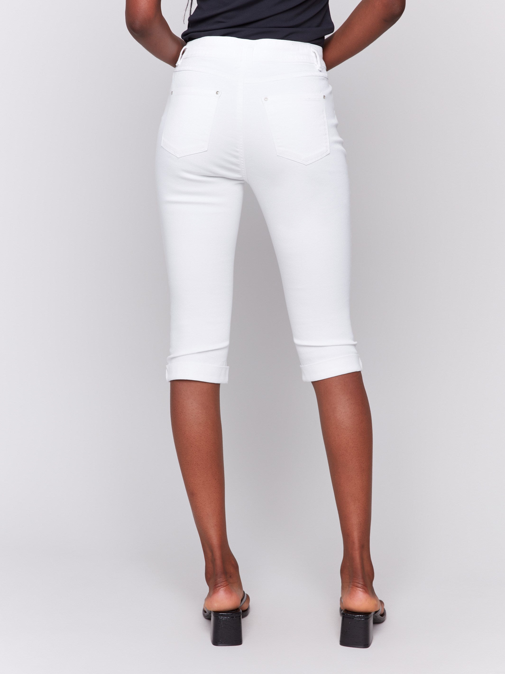 Mid-rise waist white pedal pushers with elegant folded hem details by Charlie B.