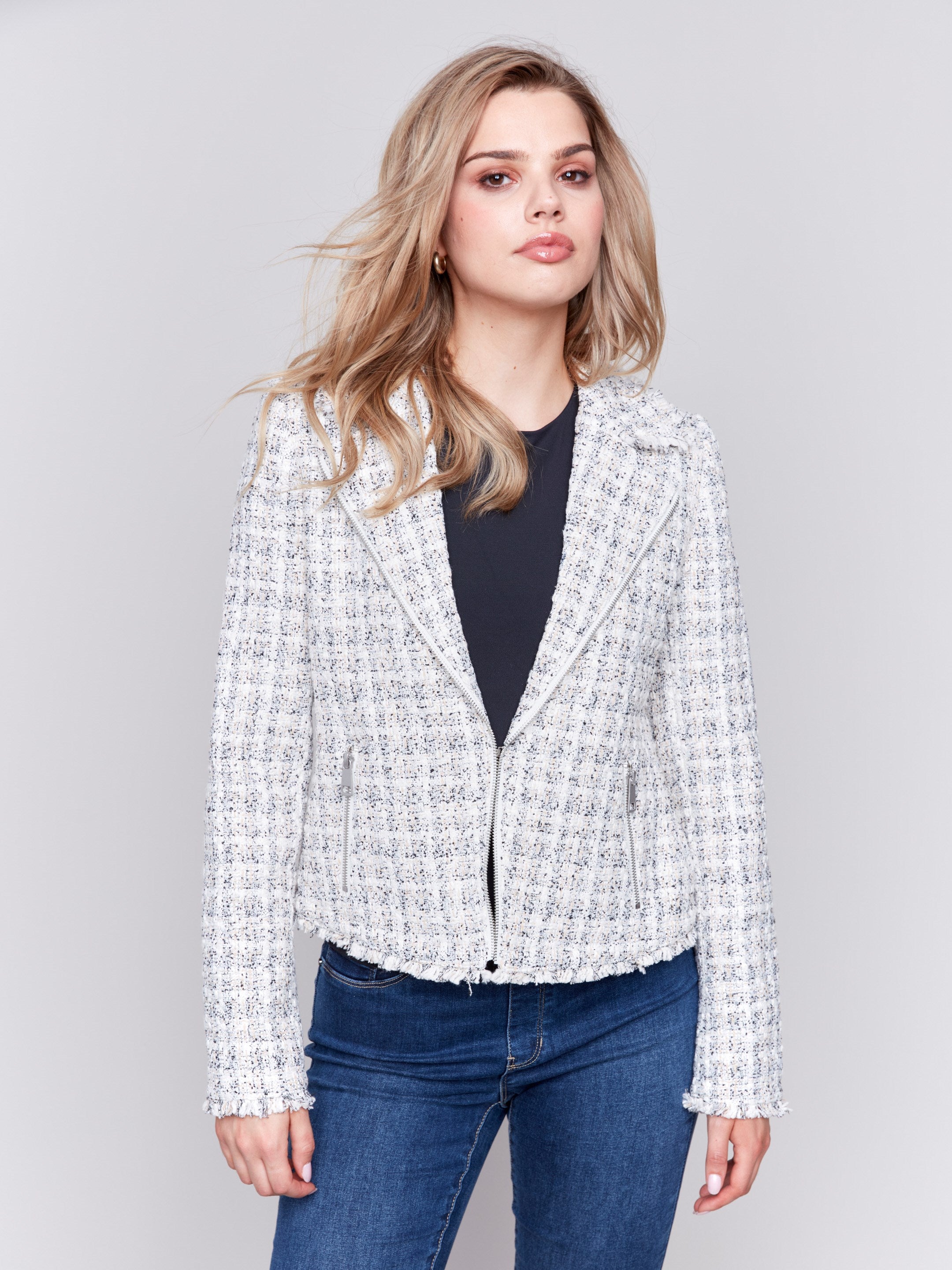 White tweed perfecto jacket with a lapel notch collar, side pockets, and hook-and-eye closure by Charlie B.