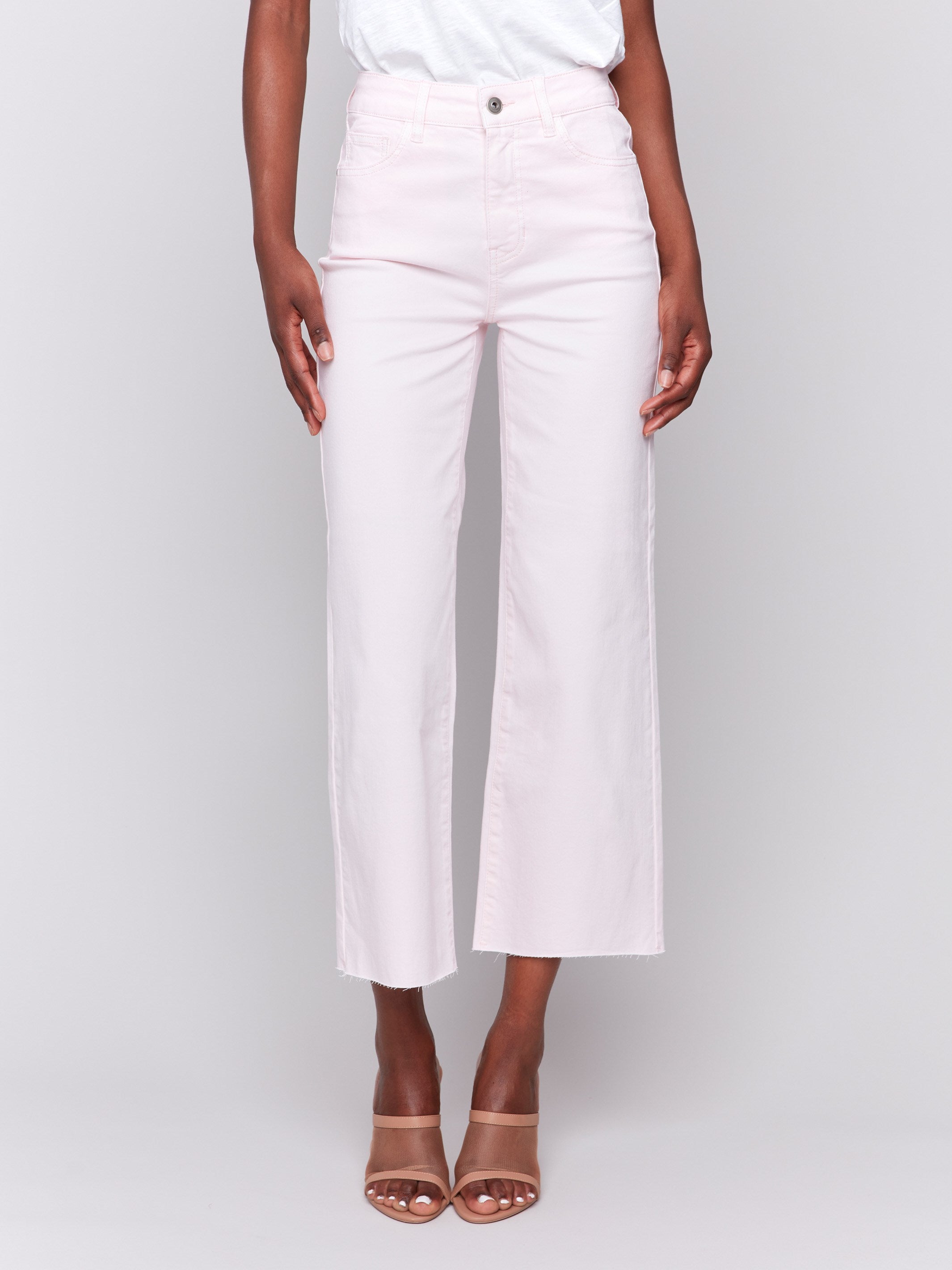 Light pink wide-leg twill pants with raw edge hem, five-pocket design, and regular rise by Charlie B.