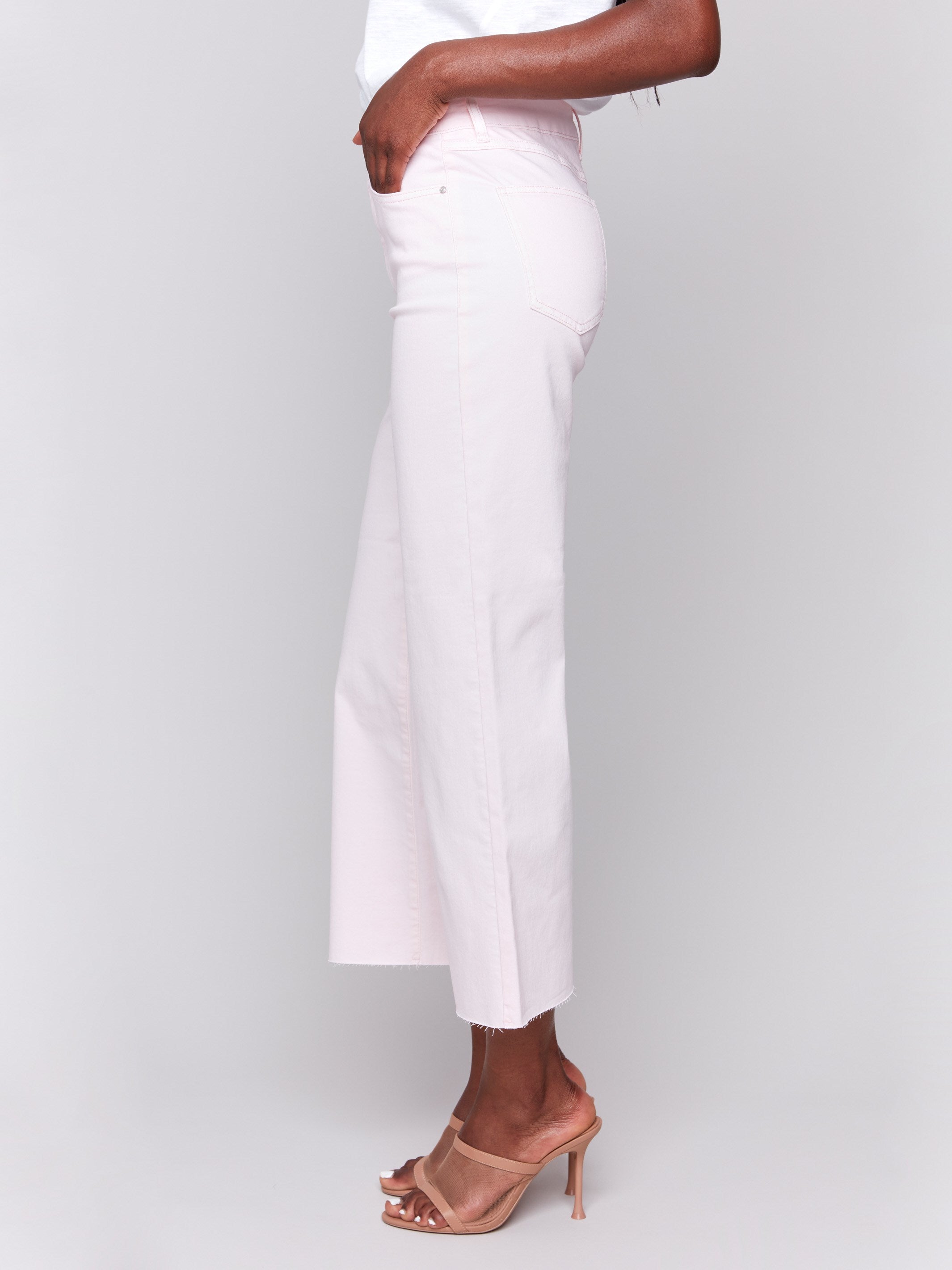 Light pink wide-leg twill pants with raw edge hem, five-pocket design, and regular rise by Charlie B.